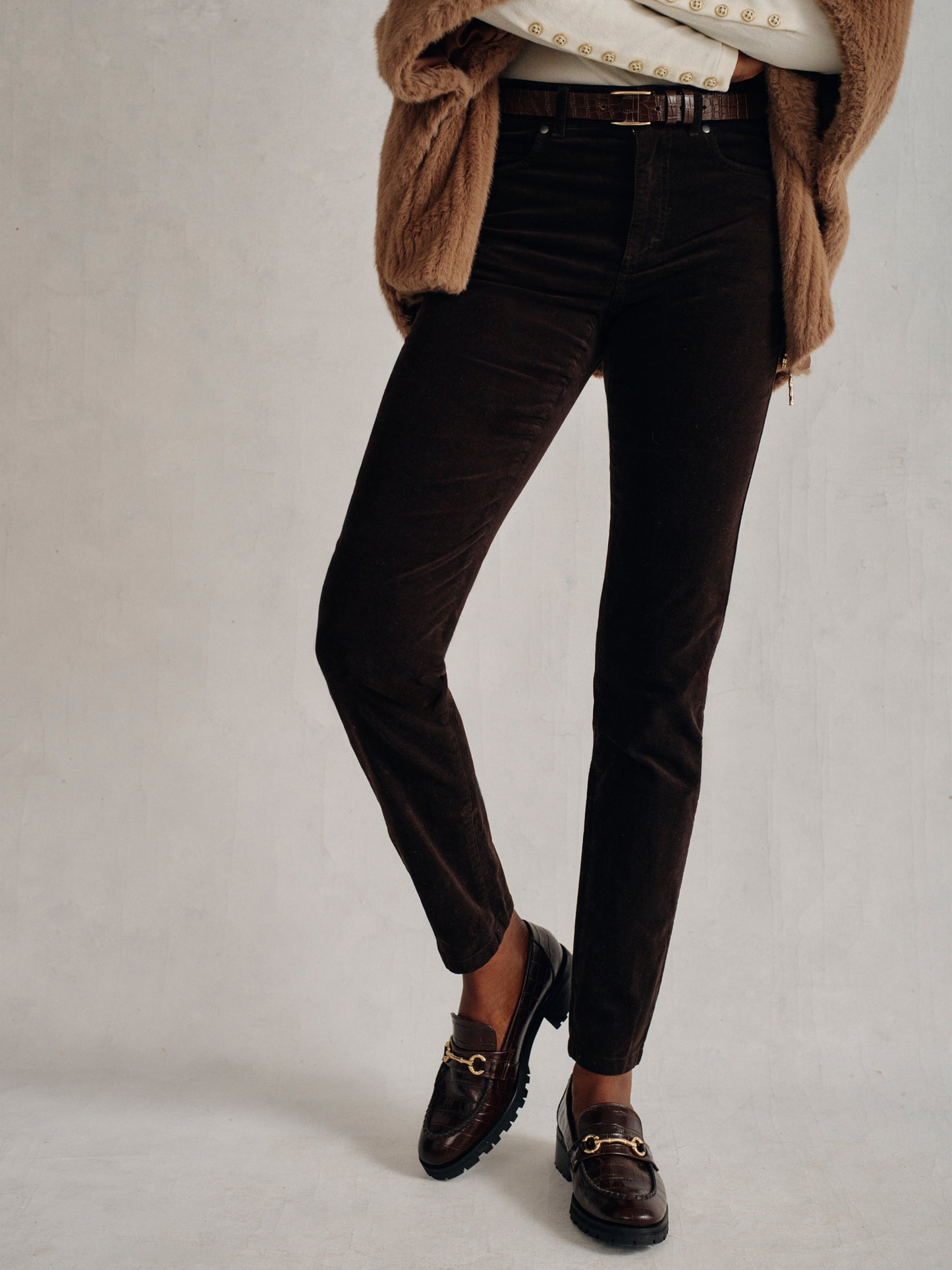Model wearing J.McLaughlin Watson jeans in dark chocolate made with velveteen.