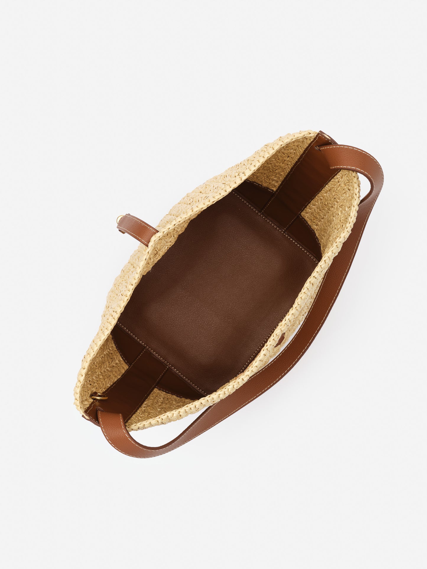 Open top view of the Crawford Raffia Handbag by J.McLaughlin, featuring a woven raffia exterior with smooth brown leather interior and handles, showcasing effortlessly stylish, enduring designs.