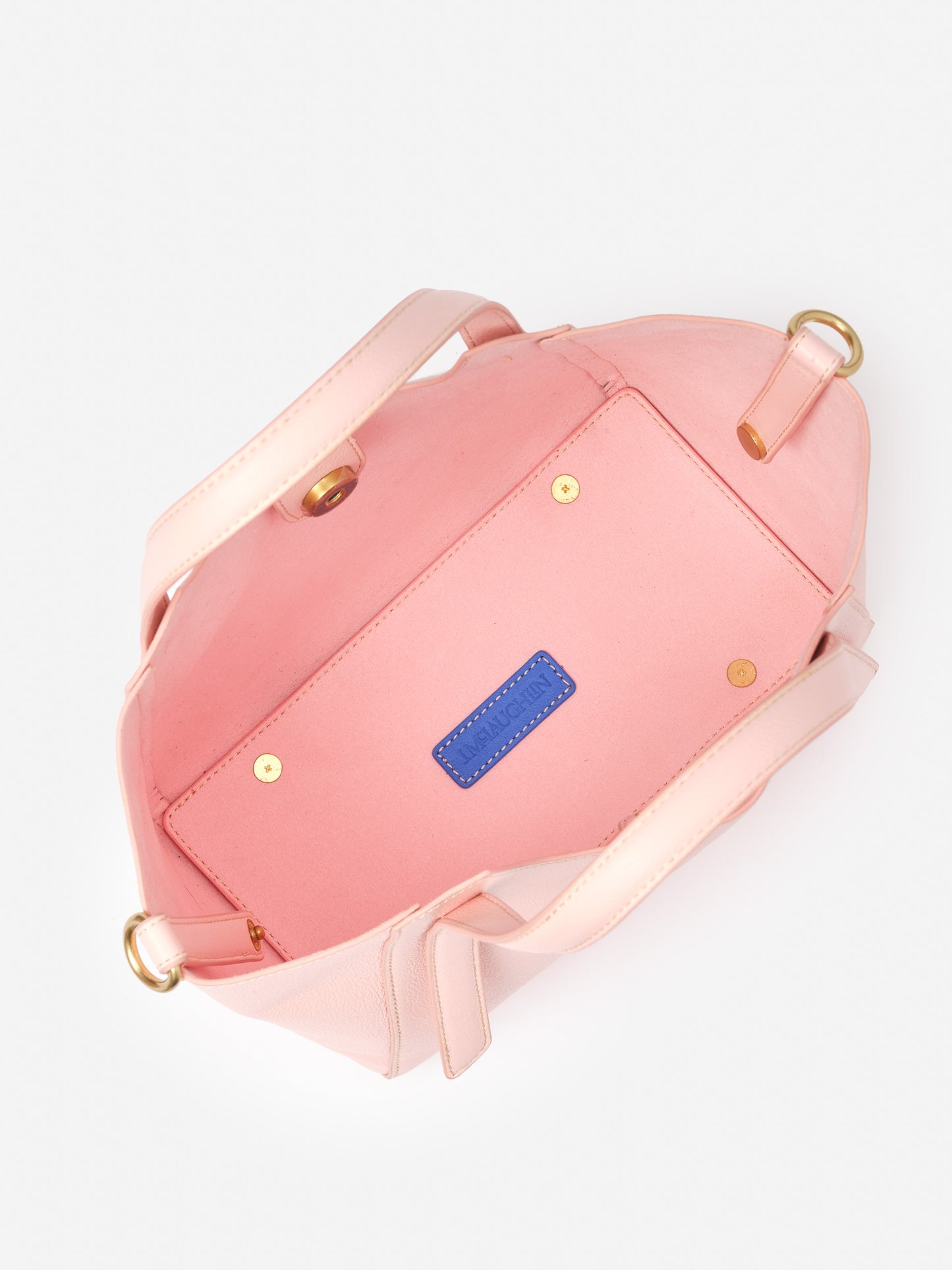 Interior view of a pink Lane Leather Mini Tote by J.McLaughlin, showcasing impeccable craftsmanship and durable detailing, epitomizing effortlessly stylish, enduring designs for life well-lived.