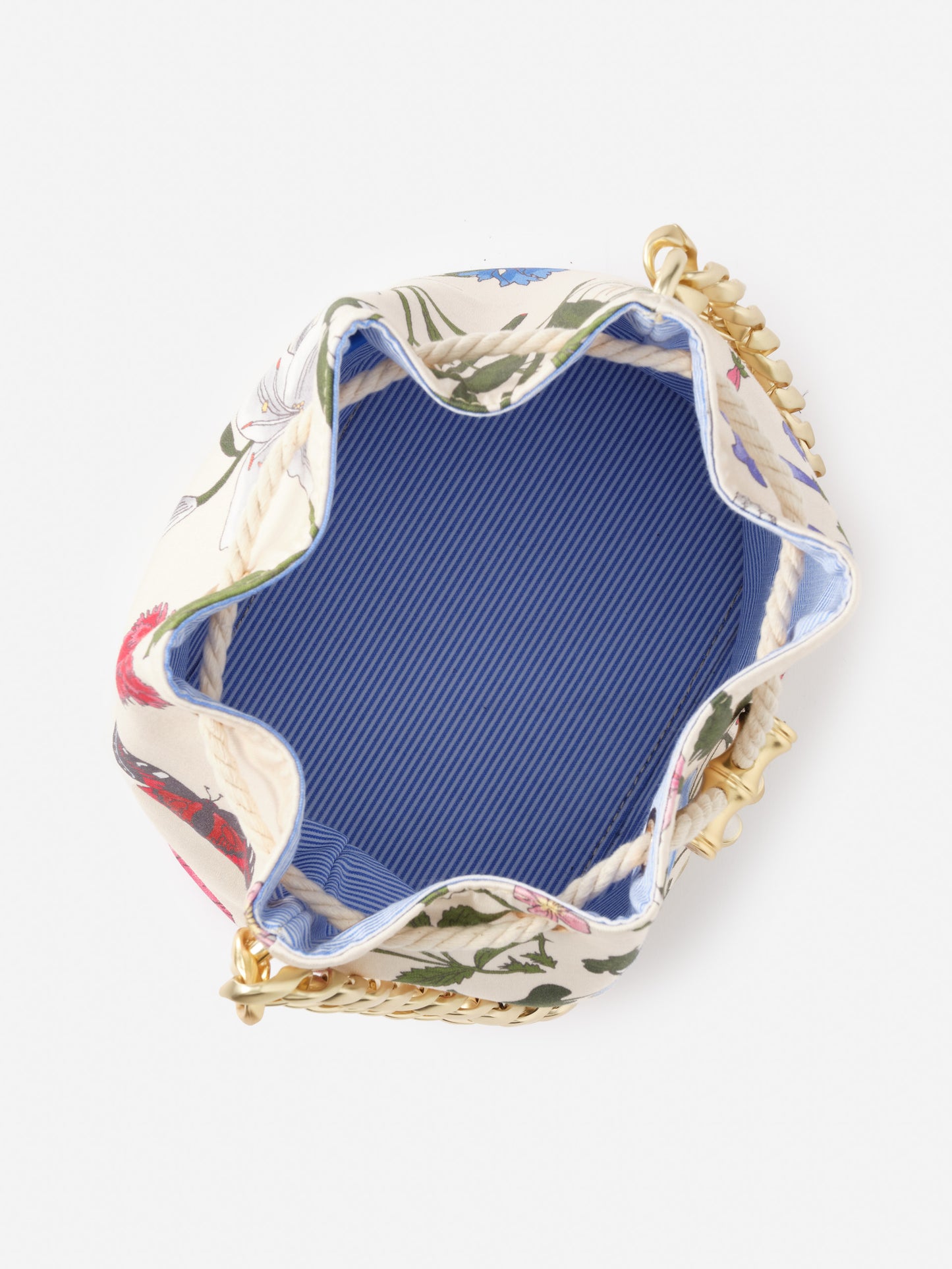 Open top view of Sarah Bucket Bag in Dragonfly Garden by J. McLaughlin featuring a floral exterior, blue interior lining, and gold chain strap, showcasing effortlessly stylish design and enduring craftsmanship.