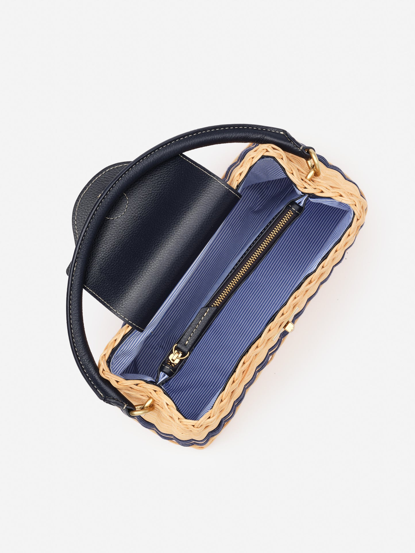 Open Faith Wicker Handbag by J.McLaughlin showing navy leather flap and handle, woven wicker frame, and striped fabric interior with zipper pocket, embodying effortlessly stylish, enduring designs from a destination for defining style. Life, Well-Lived.