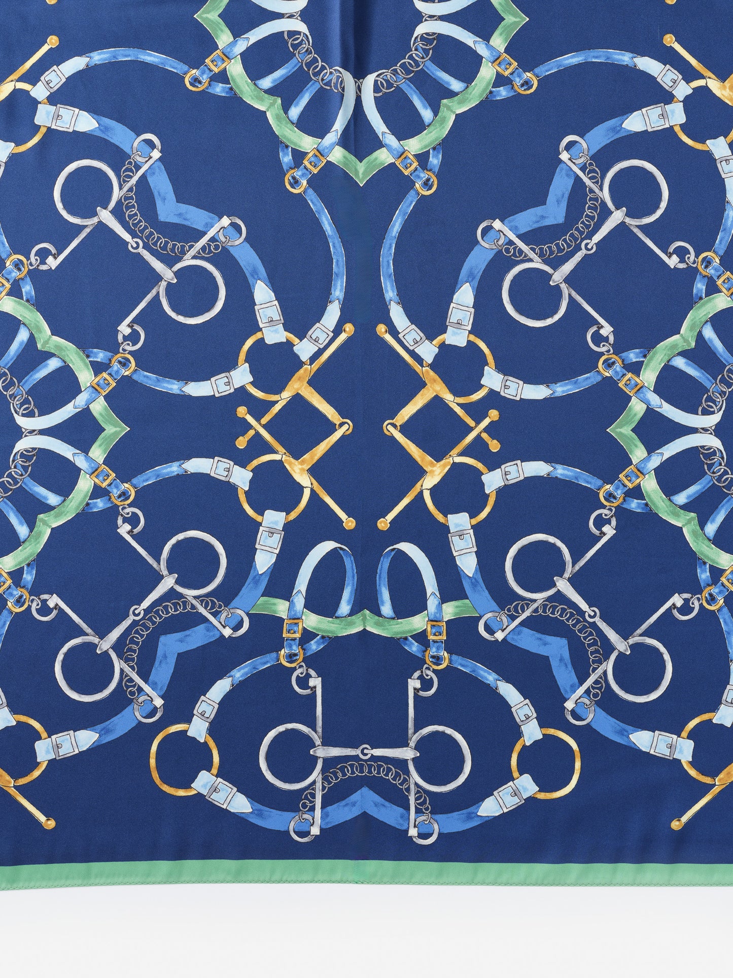 The Magic Scarf in Modern Dressage Border by J.McLaughlin features an elegantly patterned design with horse bridles and bits on a rich blue background, showcasing effortlessly stylish and enduring designs with innovative fabrics, a legacy of timeless fashion. A destination for defining style. Life, Well-Lived.