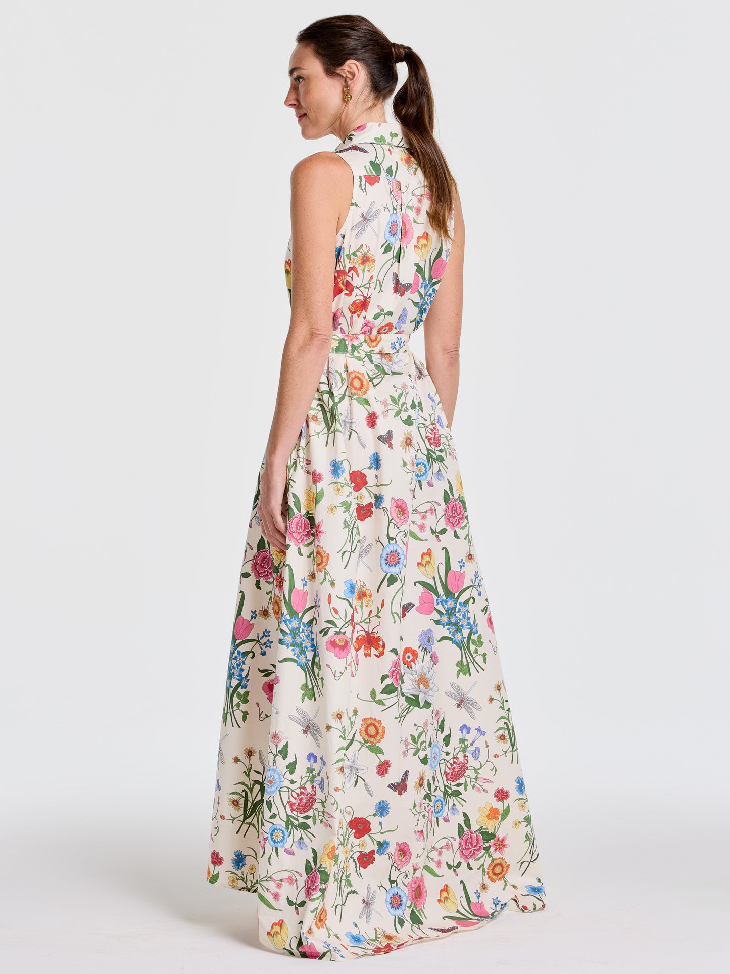 Woman wearing the Audrey Dress in Dragonfly Garden by J.McLaughlin, a sleeveless, floral-printed maxi dress with a high collar, showcasing effortlessly stylish, enduring designs in innovative fabrics for a legacy of timeless fashion. A destination for defining style. Life, Well-Lived.