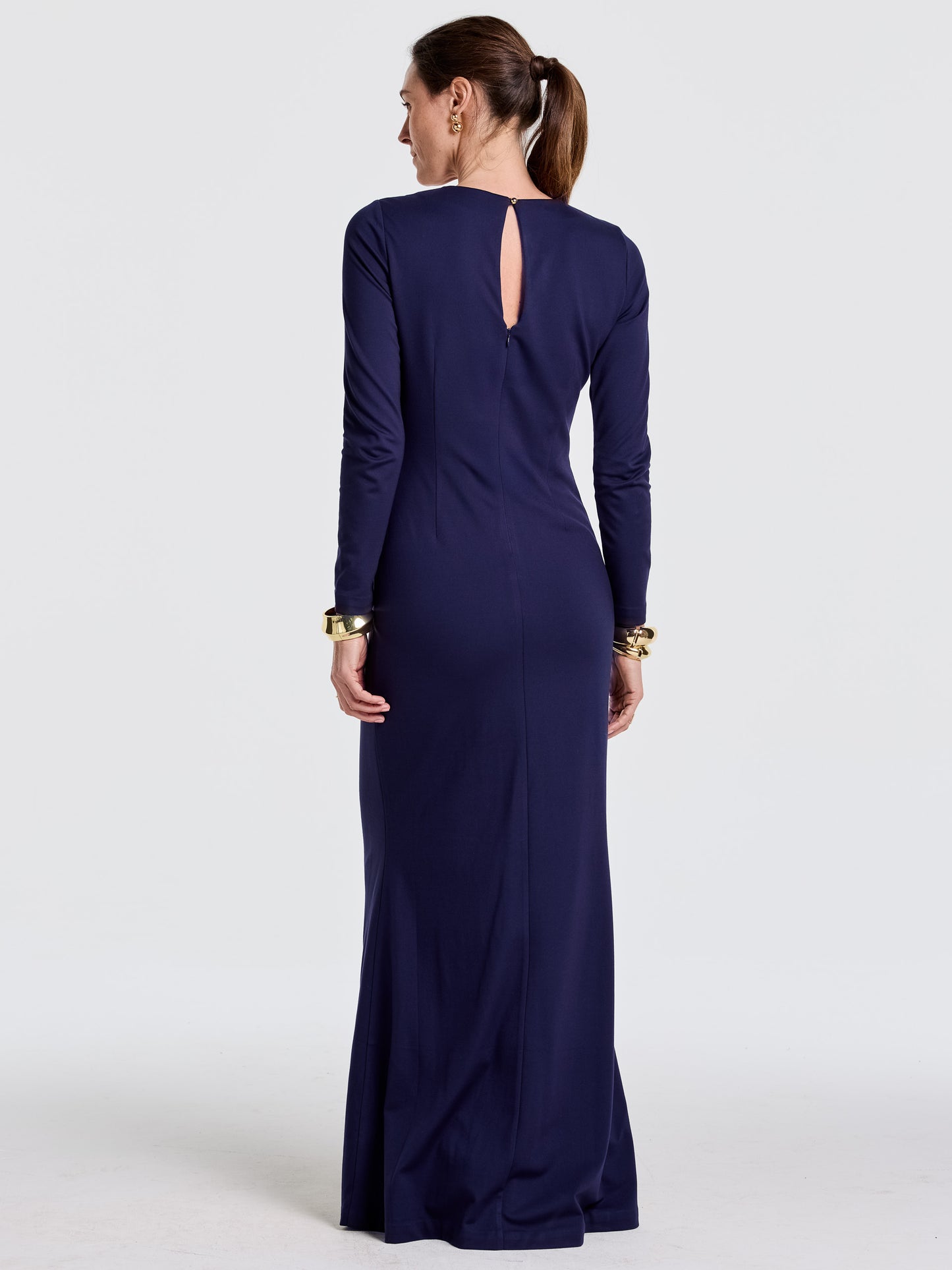 Woman wearing a navy blue Alexandra Dress by J.McLaughlin, showcasing enduring designs with innovative fabrics and impeccable craftsmanship, embodying a destination for defining style. Life, Well-Lived.
