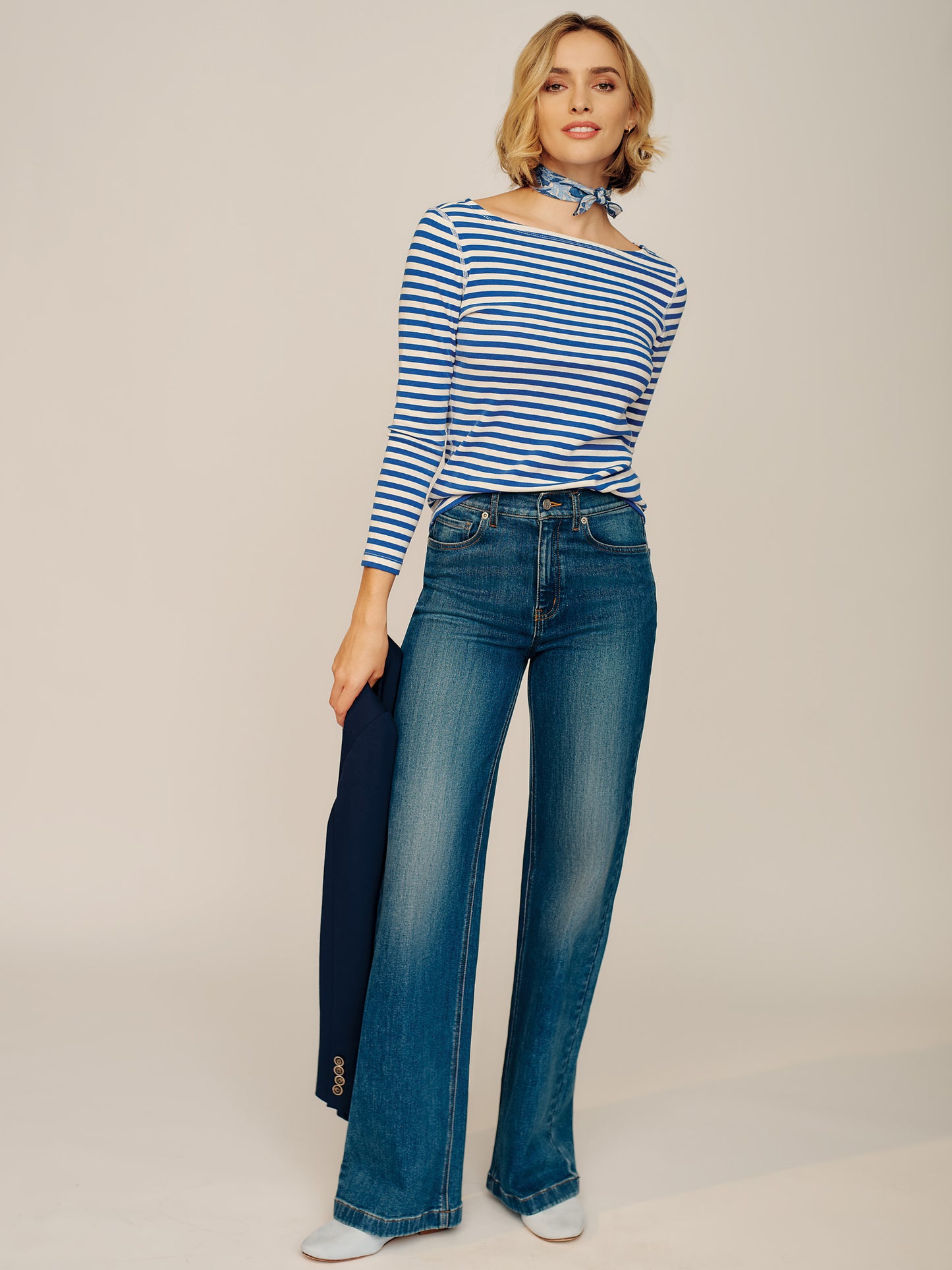 Model wearing J.McLaughlin Lowden jeans in dark indigo made with cotton.