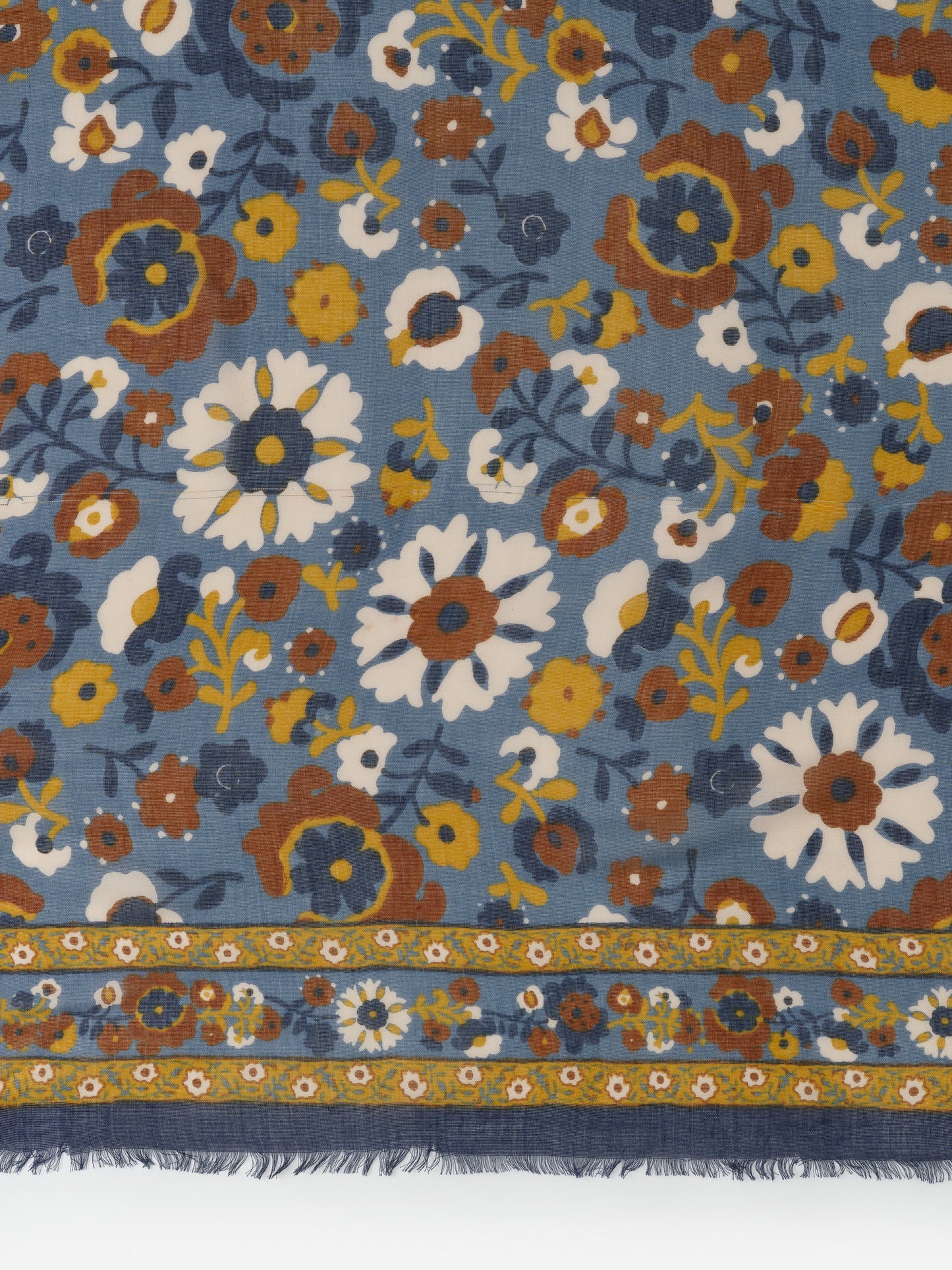 Close-up of the Giselle Scarf in Floral Daydream Border by J.McLaughlin featuring a blue background with vintage-inspired floral patterns in white, mustard, and brown, showcasing effortlessly stylish, enduring designs and innovative fabrics from a destination for defining style. Life, Well-Lived.