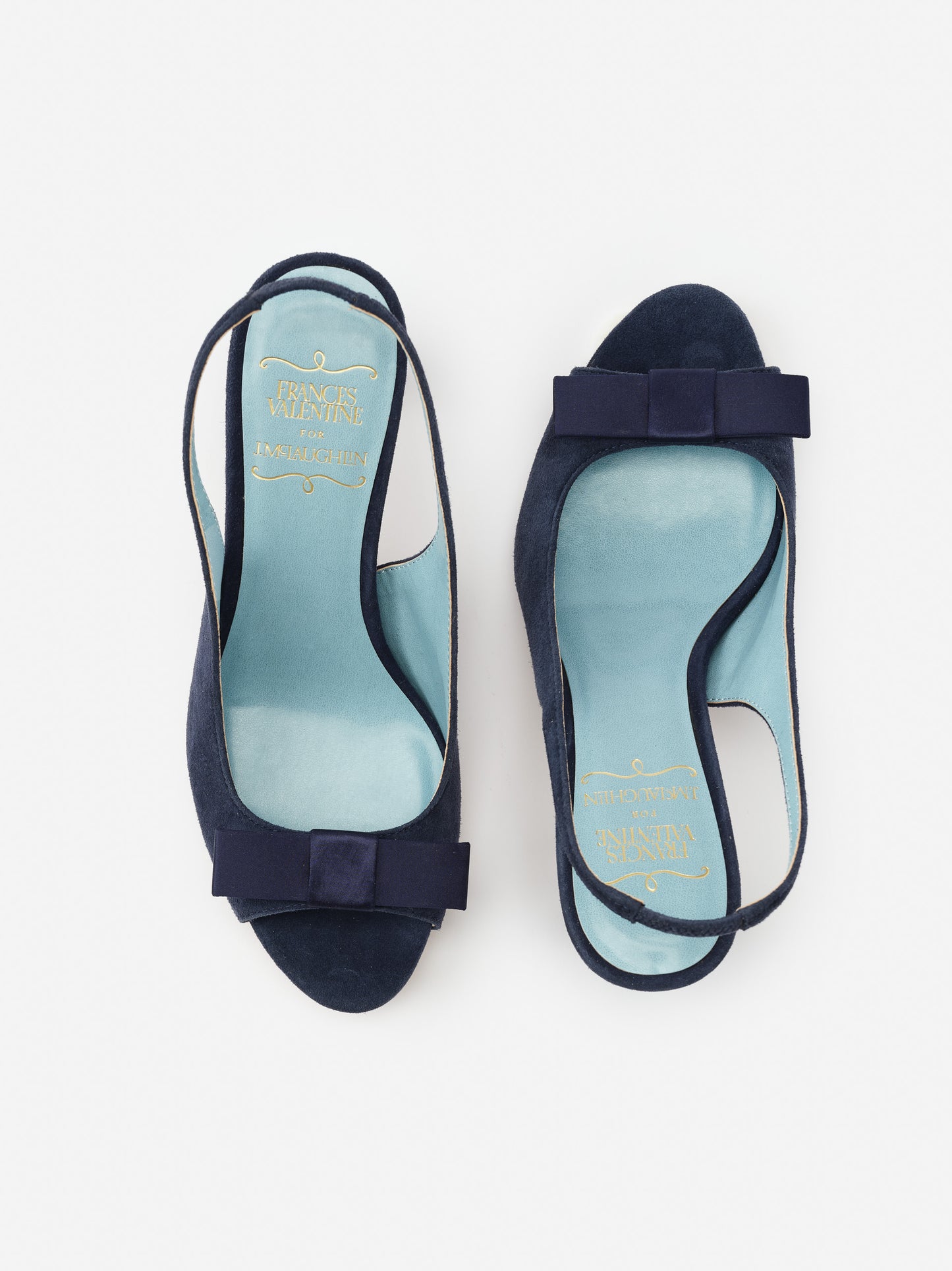 Reese Suede Slingbacks in navy by J.McLaughlin feature effortlessly stylish suede material with a chic bow detail, embodying enduring designs and a legacy of timeless fashion.