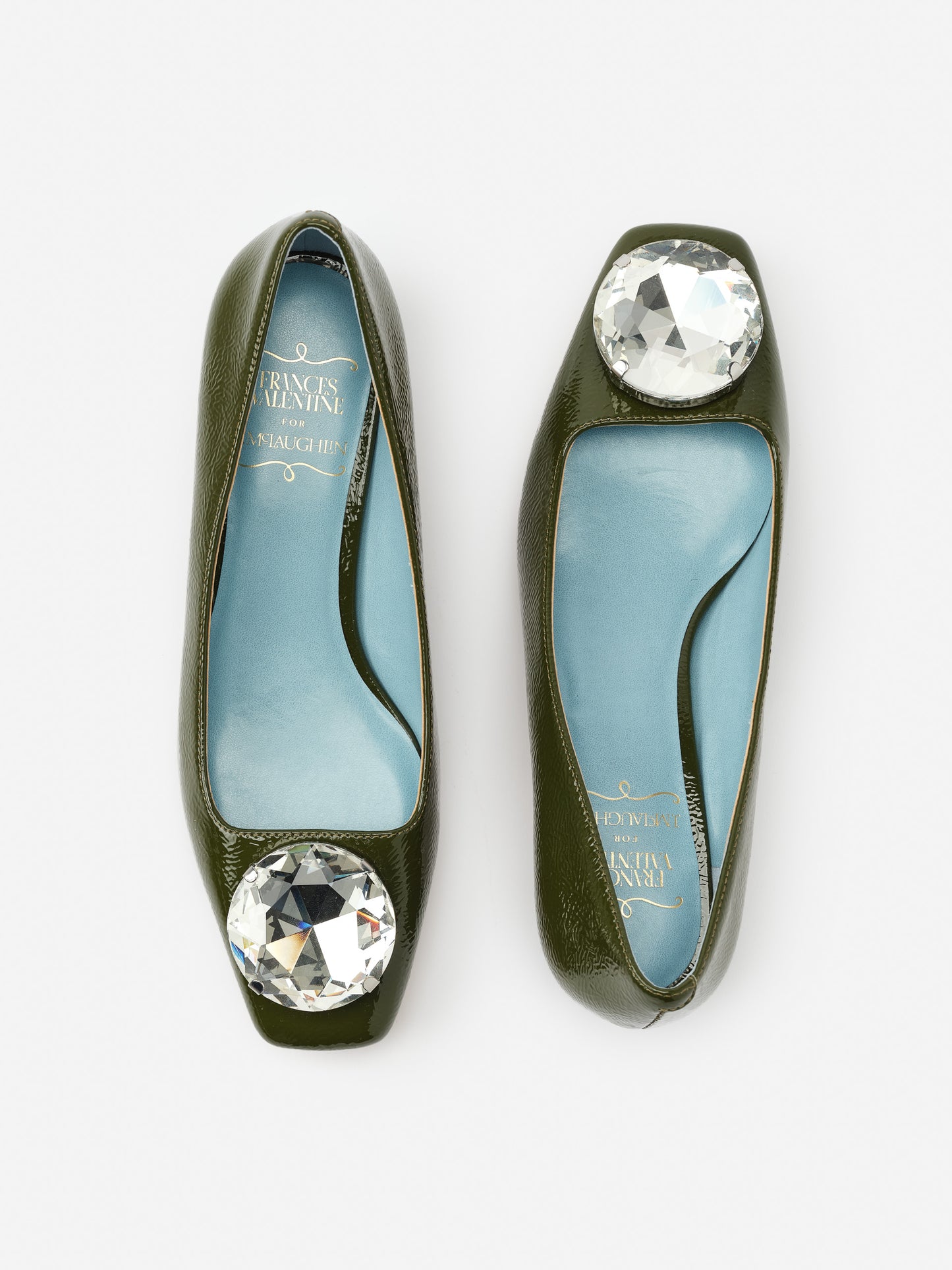 Mary Block Heels by J.McLaughlin in deep olive green leather featuring a large clear gemstone embellishment, showcasing effortlessly stylish, enduring designs with a legacy of timeless fashion.