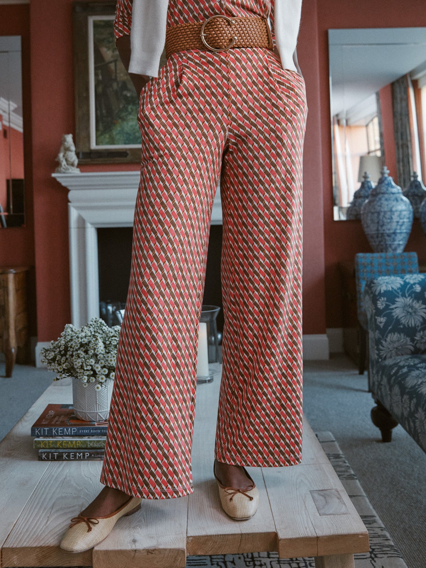 Model wears J.McLaughlin Pasha pants in coral/brown made with polyester/spandex.