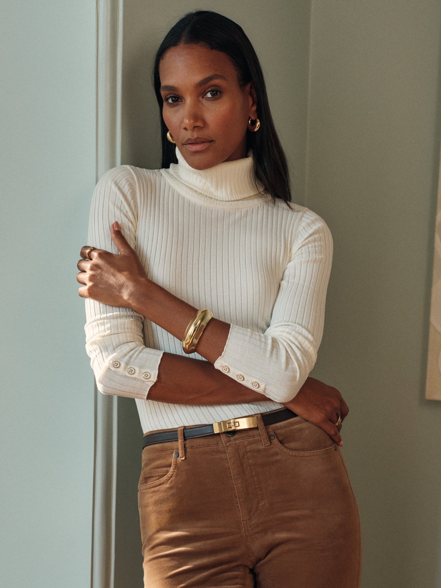 Model wearing J.McLaughlin Arlette turtleneck in egret white made with cotton/modal.