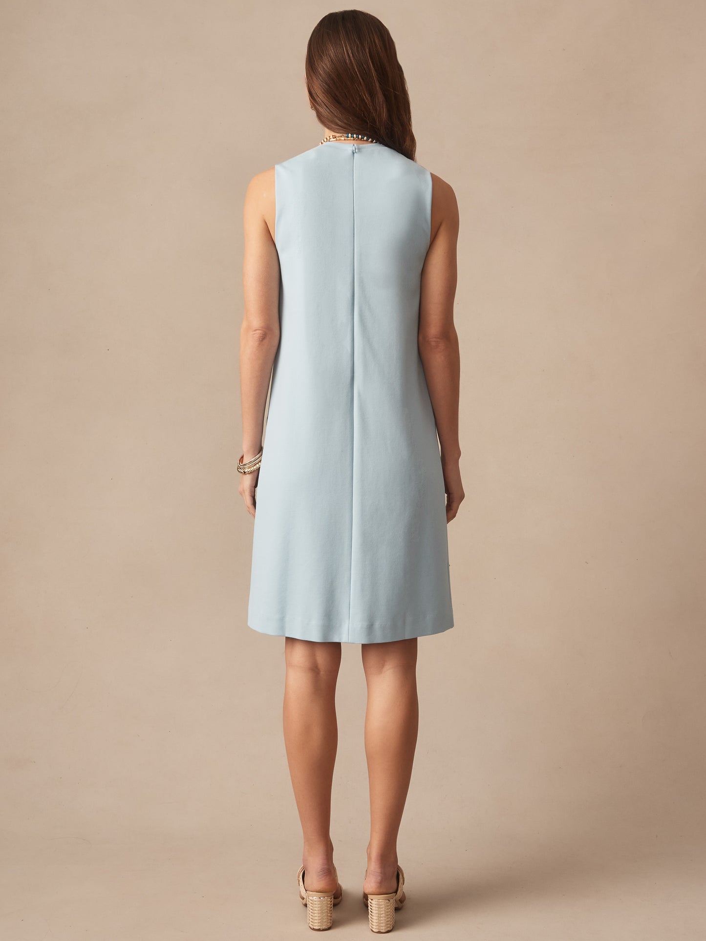 Woman wearing a sky blue Alicia Dress by J.McLaughlin, showcasing effortlessly stylish and enduring designs in a timeless, classic silhouette for defining style. Life, Well-Lived.