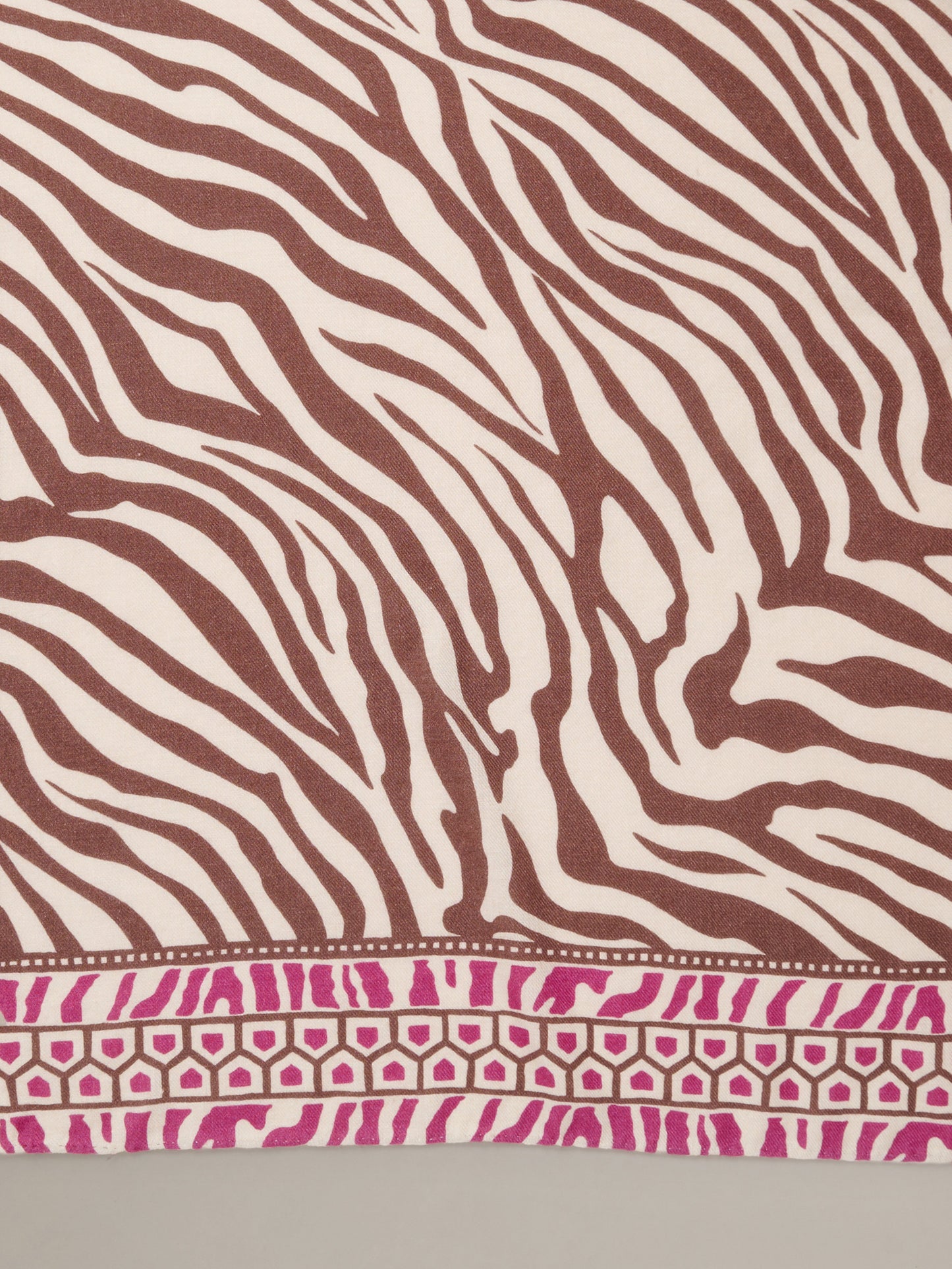 The Blair Scarf in Wild Medley Corner by J.McLaughlin featuring brown and cream zebra stripes with a pink geometric border on soft lightweight fabric