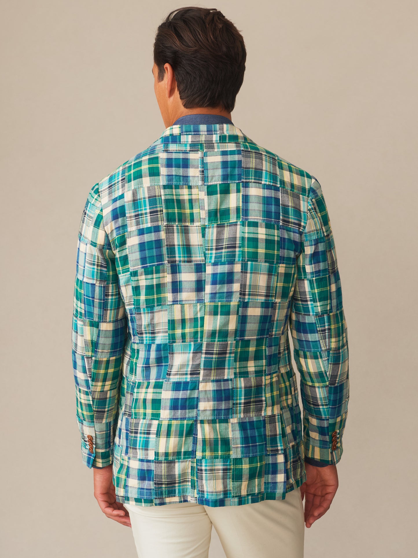 Back view of a man wearing the Brera Sport Coat in Patchwork by J.McLaughlin, featuring a vibrant blue, green, and tan checkered pattern that showcases effortlessly stylish, enduring designs and innovative fabrics from a legacy of timeless fashion. A destination for defining style. Life, Well-Lived.