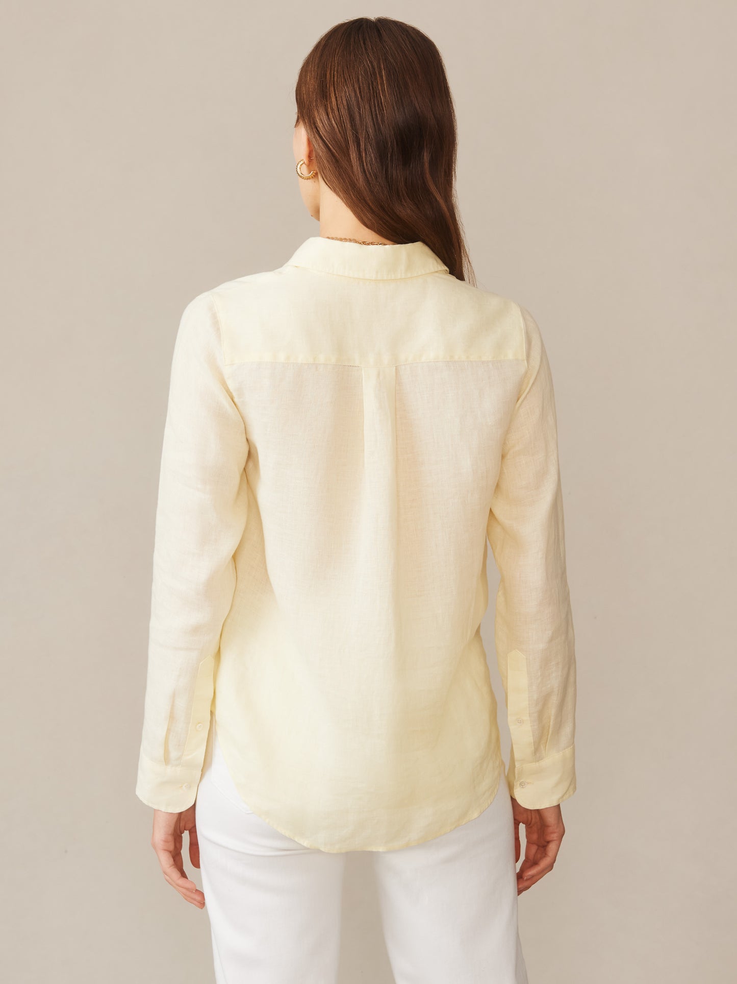 A woman wearing a lemon-colored Britt Linen Shirt by J.McLaughlin, showcasing effortlessly stylish, enduring designs crafted from innovative fabrics for a legacy of timeless fashion.