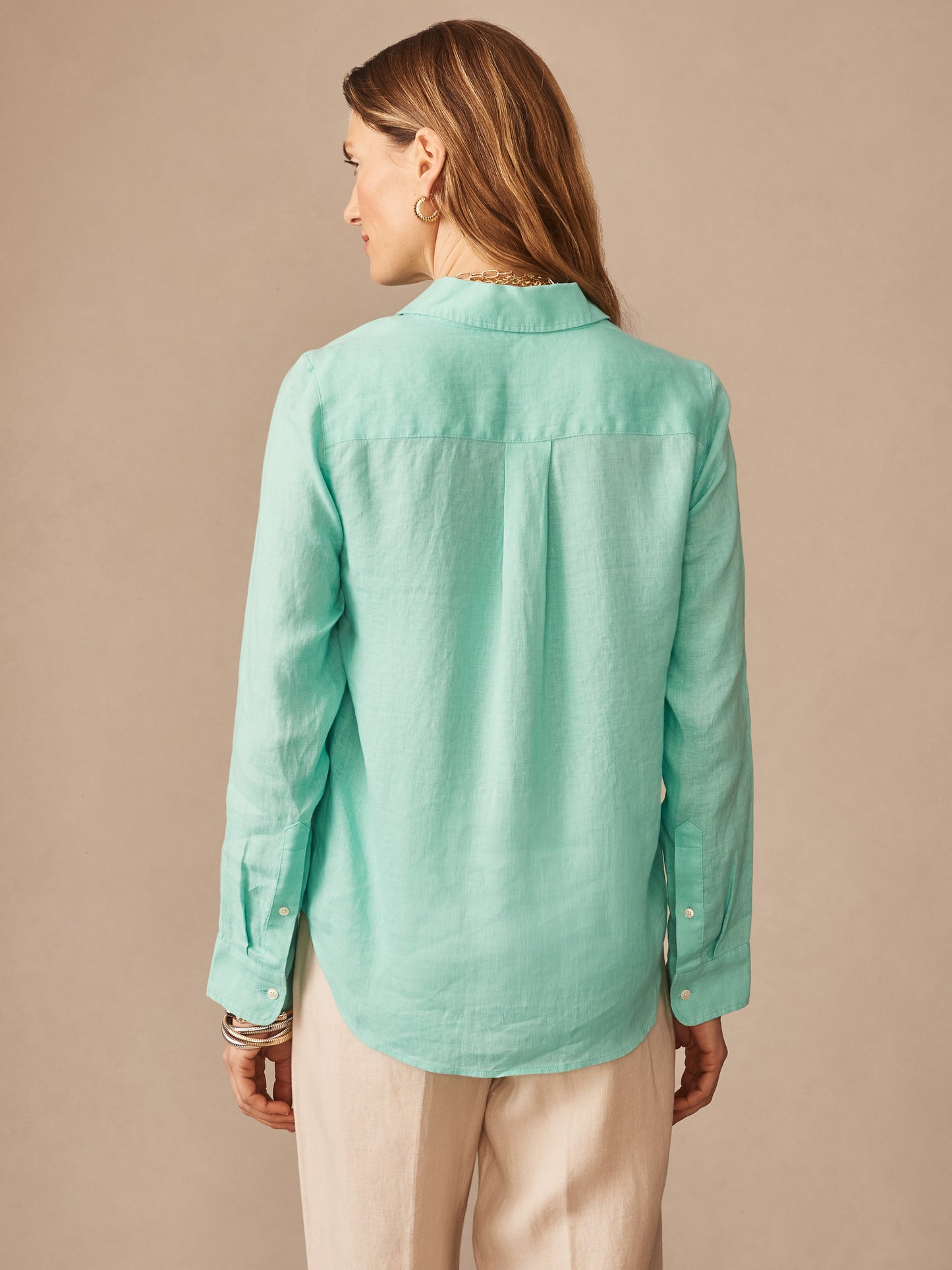 Woman wearing a seafoam green Britt Linen Shirt by J.McLaughlin, showcasing effortlessly stylish, enduring designs with innovative fabrics, a destination for defining style. Life, Well-Lived.