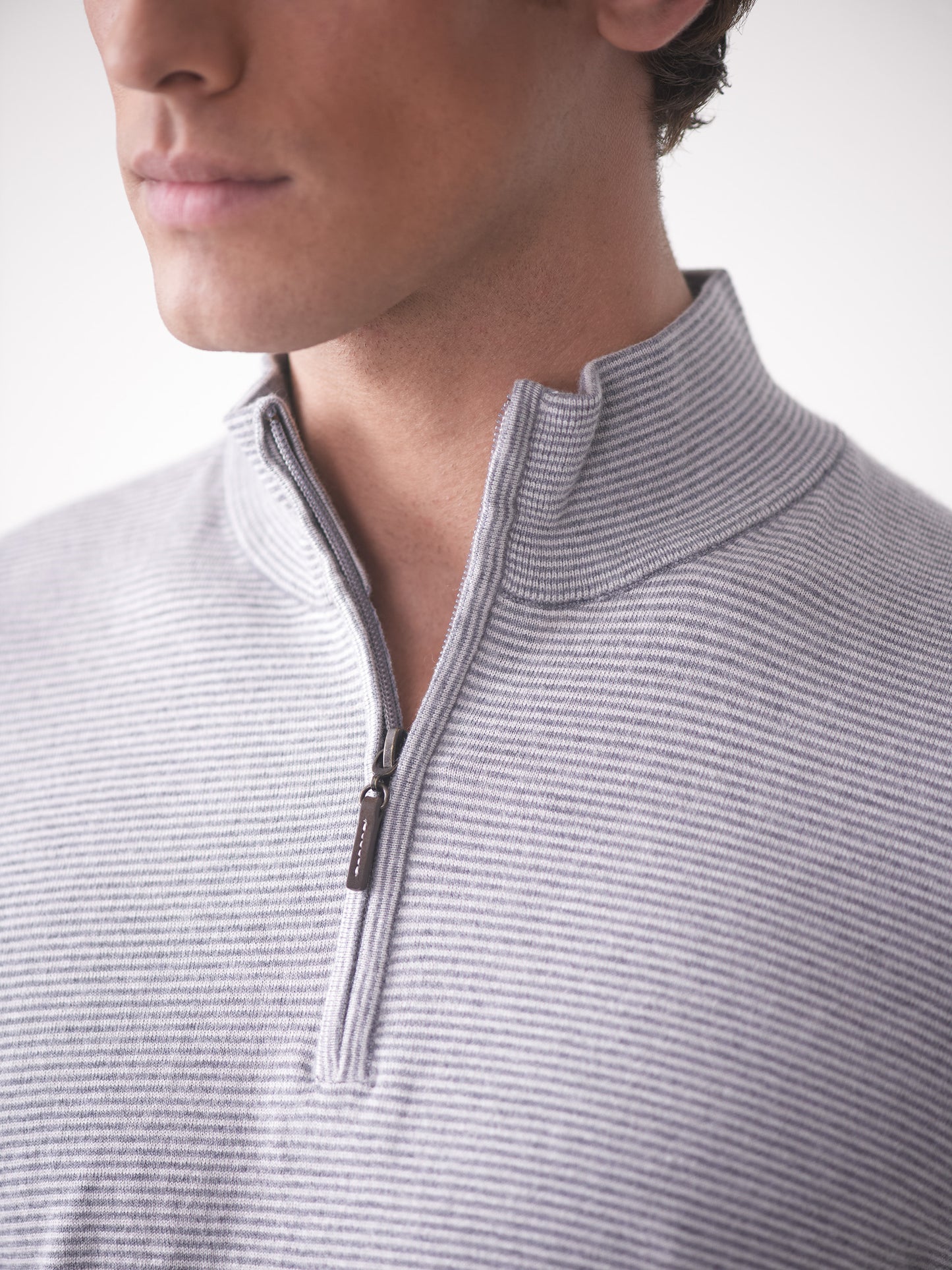 Model wearing J.McLaughlin Brookhaven sweater in gray/light gray made with cotton, viscose, nylon, and cashmere.