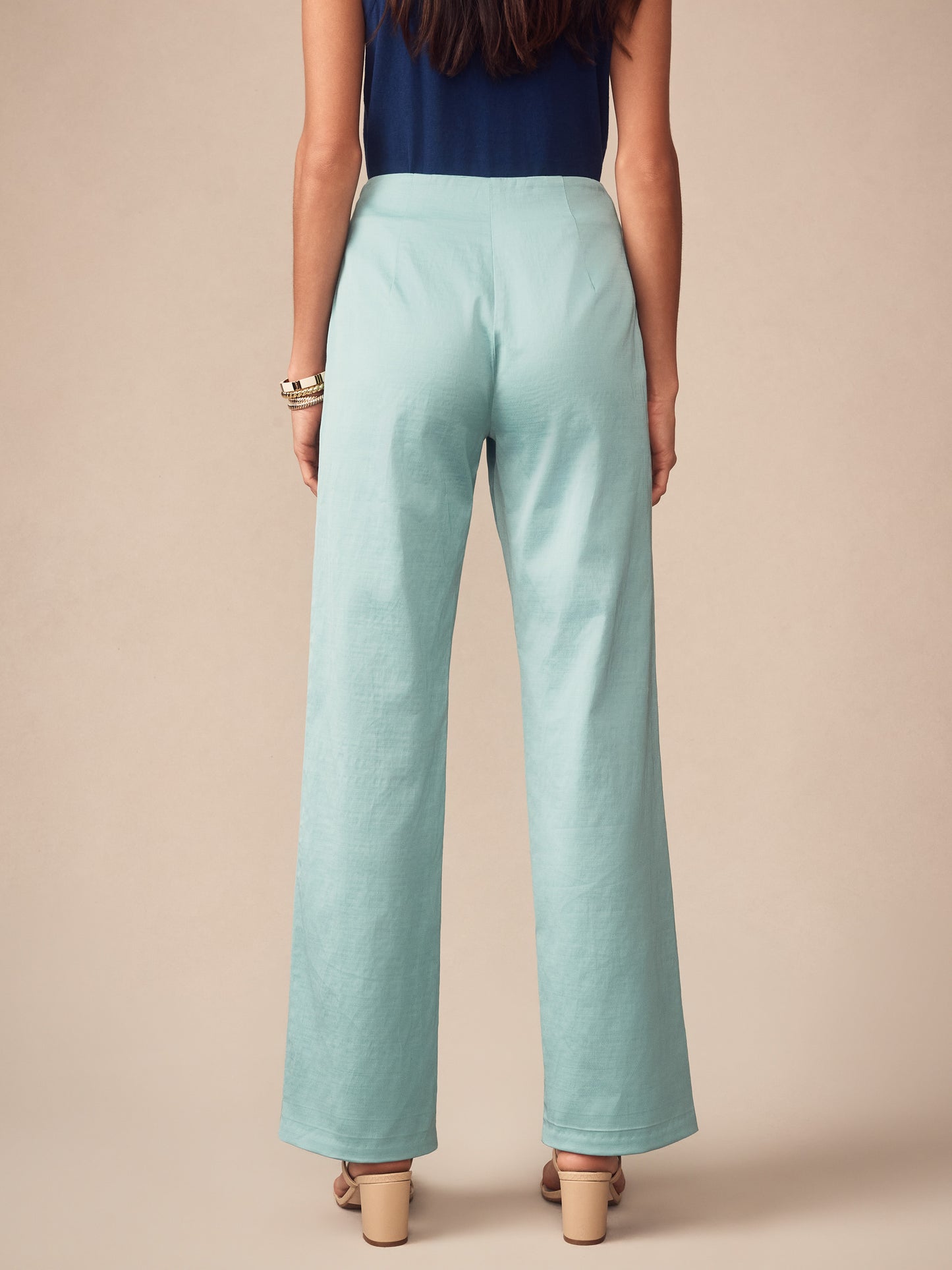 Woman wearing seafoam green Carter Dupioni Cotton Pants by J.McLaughlin paired with a navy top and beige heeled sandals, showcasing effortlessly stylish, enduring designs with innovative fabrics.