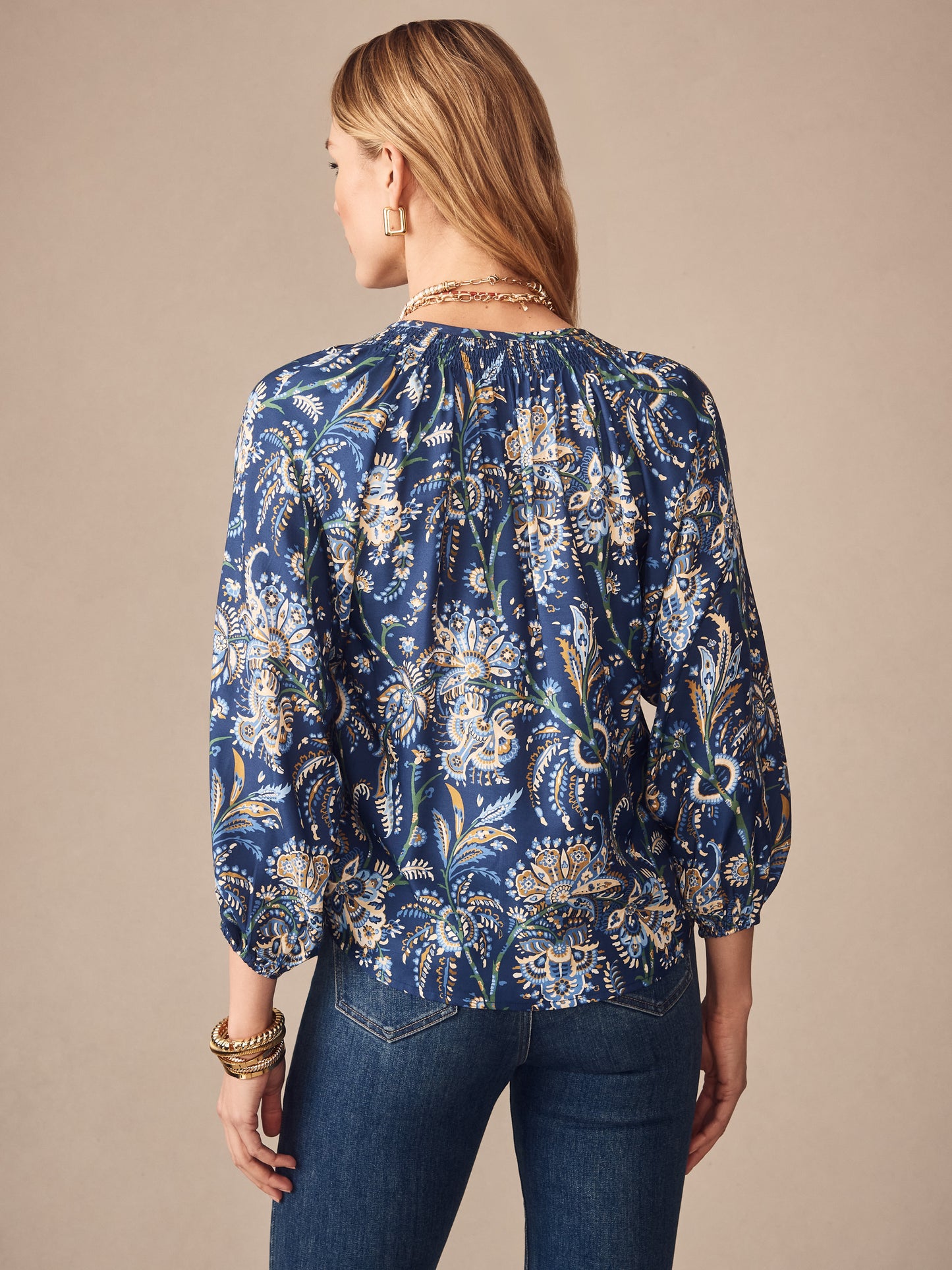 A woman wearing the Constance Silk Blend Blouse in Maxi Heirloom Paisley by J.McLaughlin, featuring a navy multi floral paisley pattern, paired with denim jeans, showcasing effortlessly stylish, enduring designs crafted from innovative fabrics. A destination for defining style. Life, Well-Lived.
