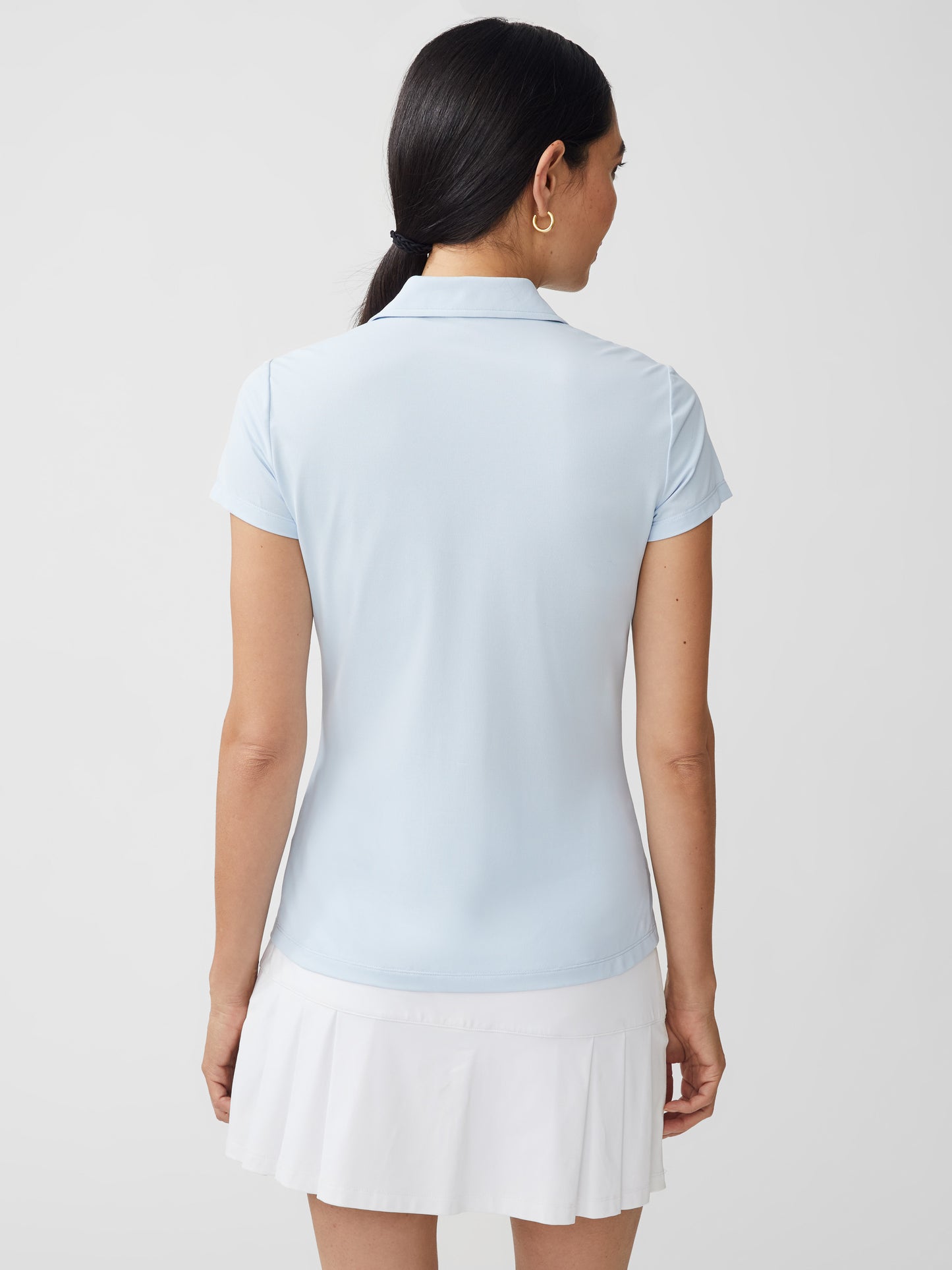 J.McLaughlin model wears Court Cap Sleeve Pique Polo in light blue made with Catalina Cloth.