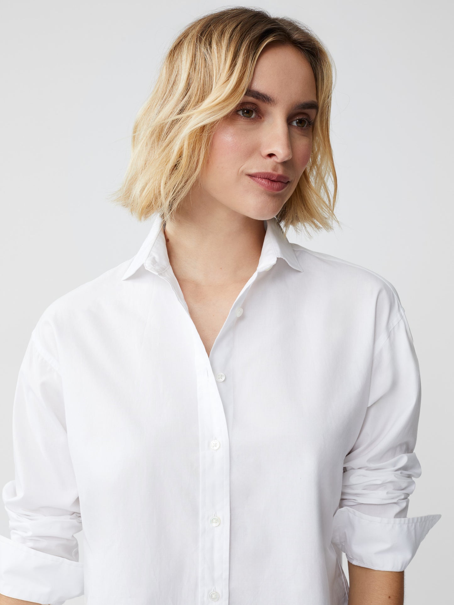 Model wearing J.McLaughlin Finn shirt in white made with cotton/modal.