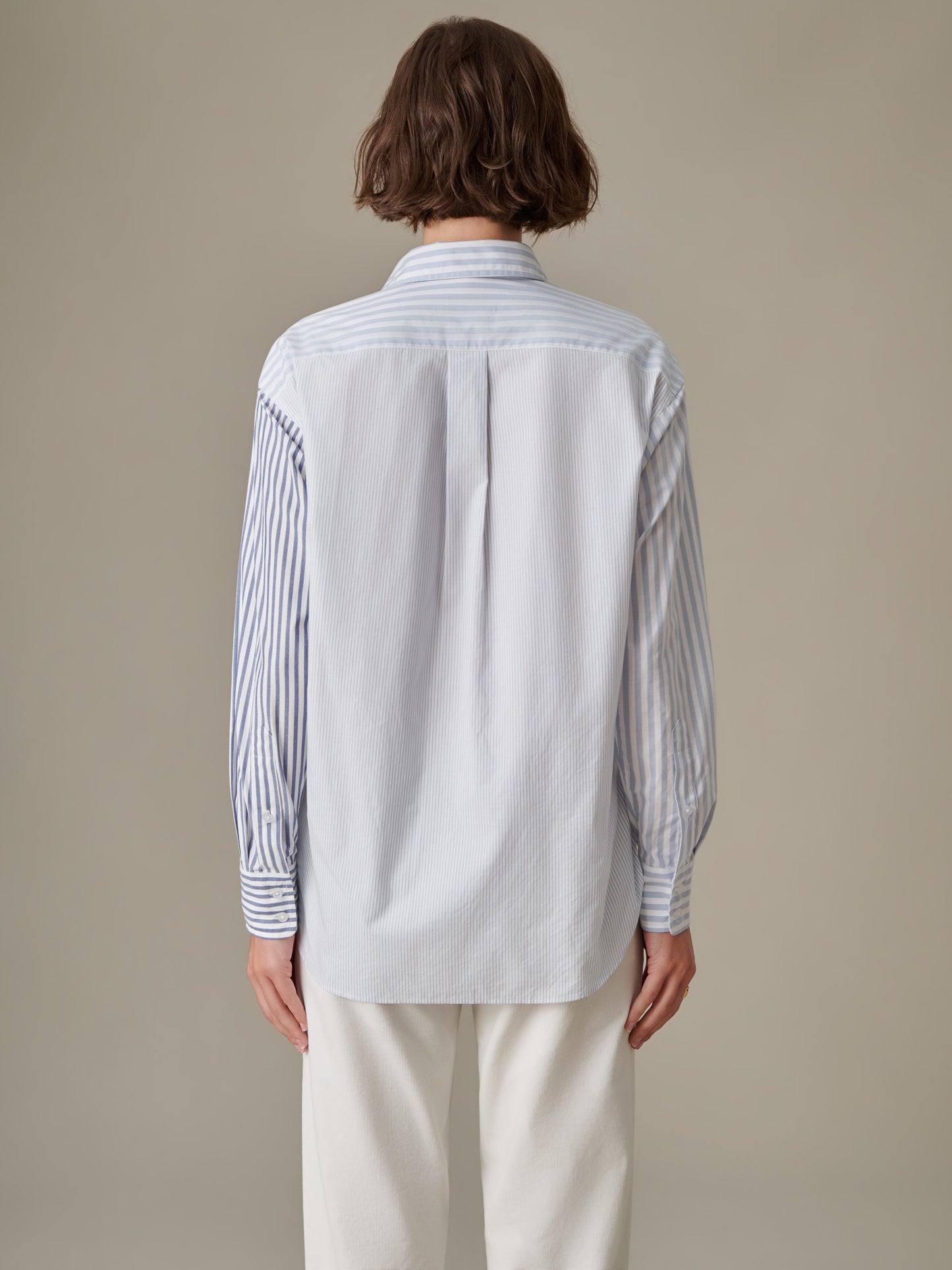 Back view of a person wearing the Finn Shirt in Stripe by J.McLaughlin, featuring a blend of classic striped fabrics with a timeless silhouette, embodying enduring design and style.