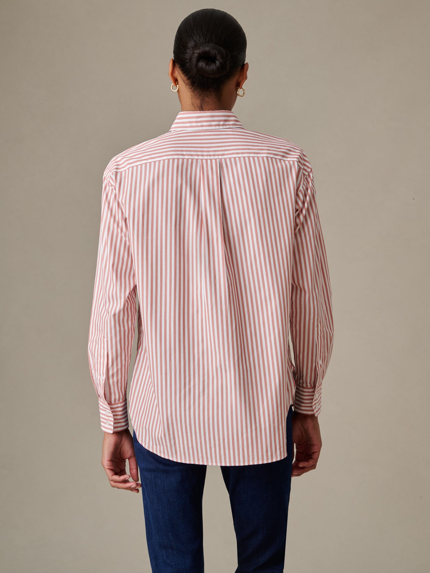 Back view of a woman wearing the Finn Shirt in Stripe by J.McLaughlin, featuring classic vertical stripes and a relaxed fit, embodying timeless style and craftsmanship.
