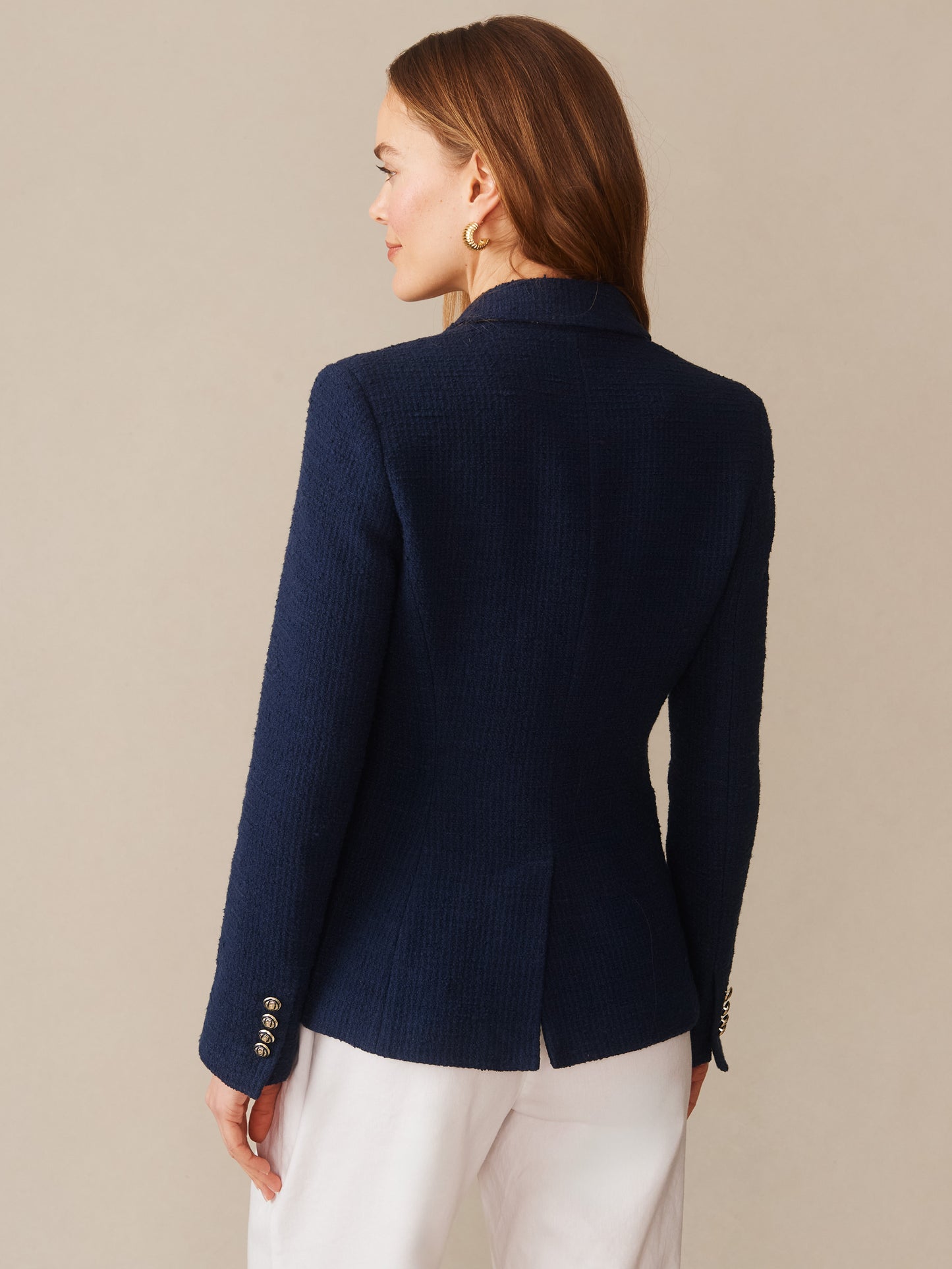 Woman seen from behind wearing a navy Genevieve Cotton Bouclé Blazer by J.McLaughlin, showcasing impeccable craftsmanship and innovative fabrics in an effortlessly stylish, enduring design.