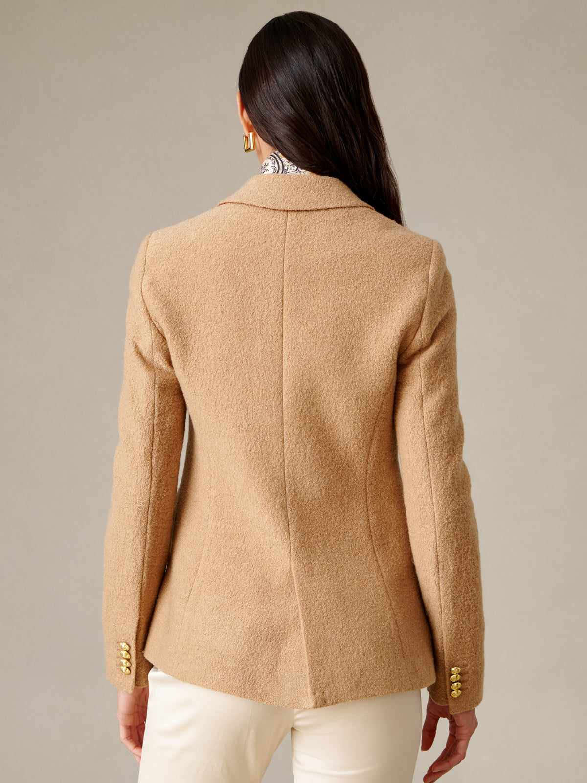 Back view of J.McLaughlin Genevieve Wool Bouclé Blazer in warm tan wool with tailored seams and button cuffs styled with white pants
