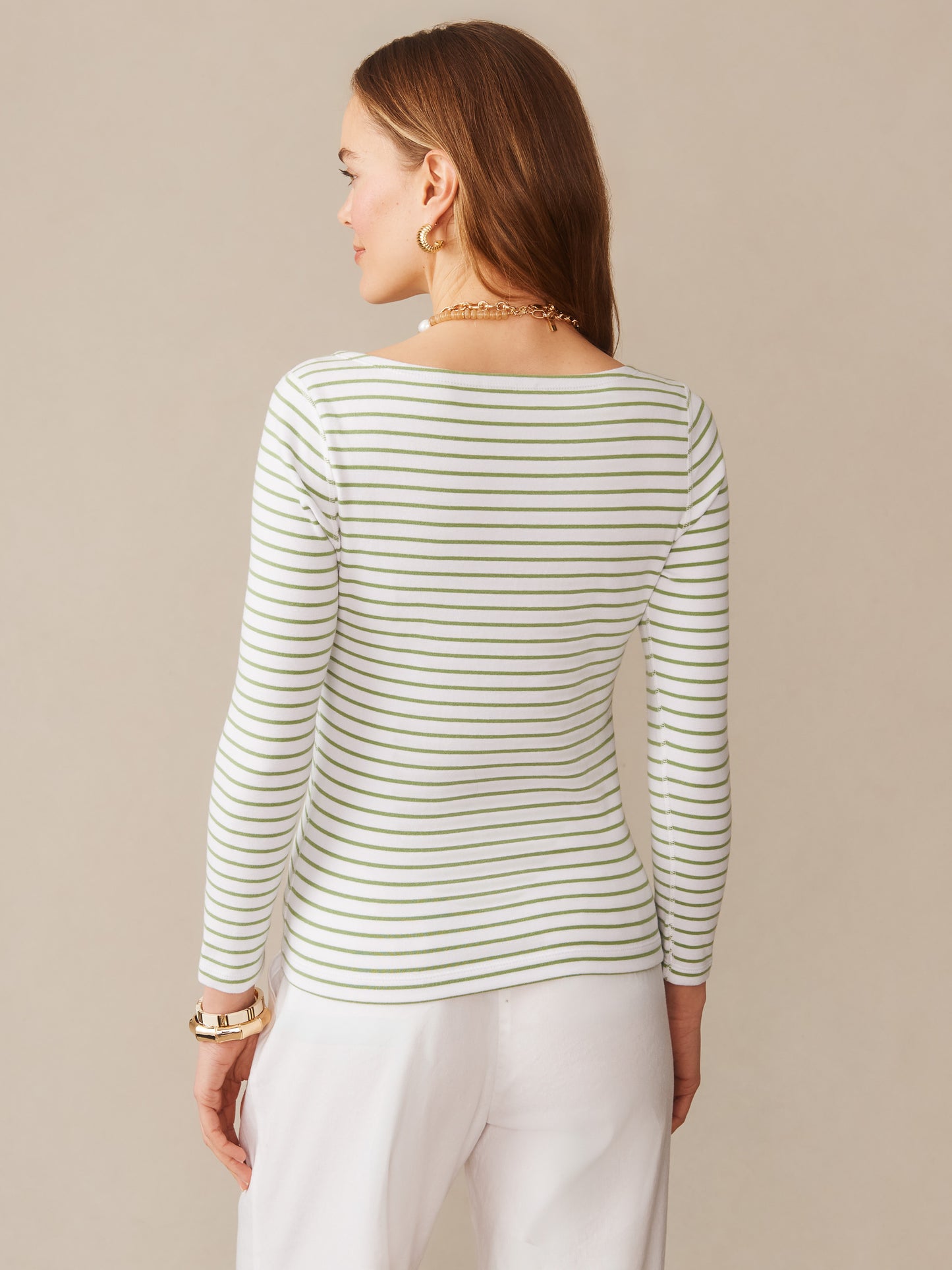 Woman wearing the Goldie Tee in Stripe by J.McLaughlin, featuring green and white stripes with a classic fit, embodying effortlessly stylish, enduring designs and a legacy of timeless fashion.