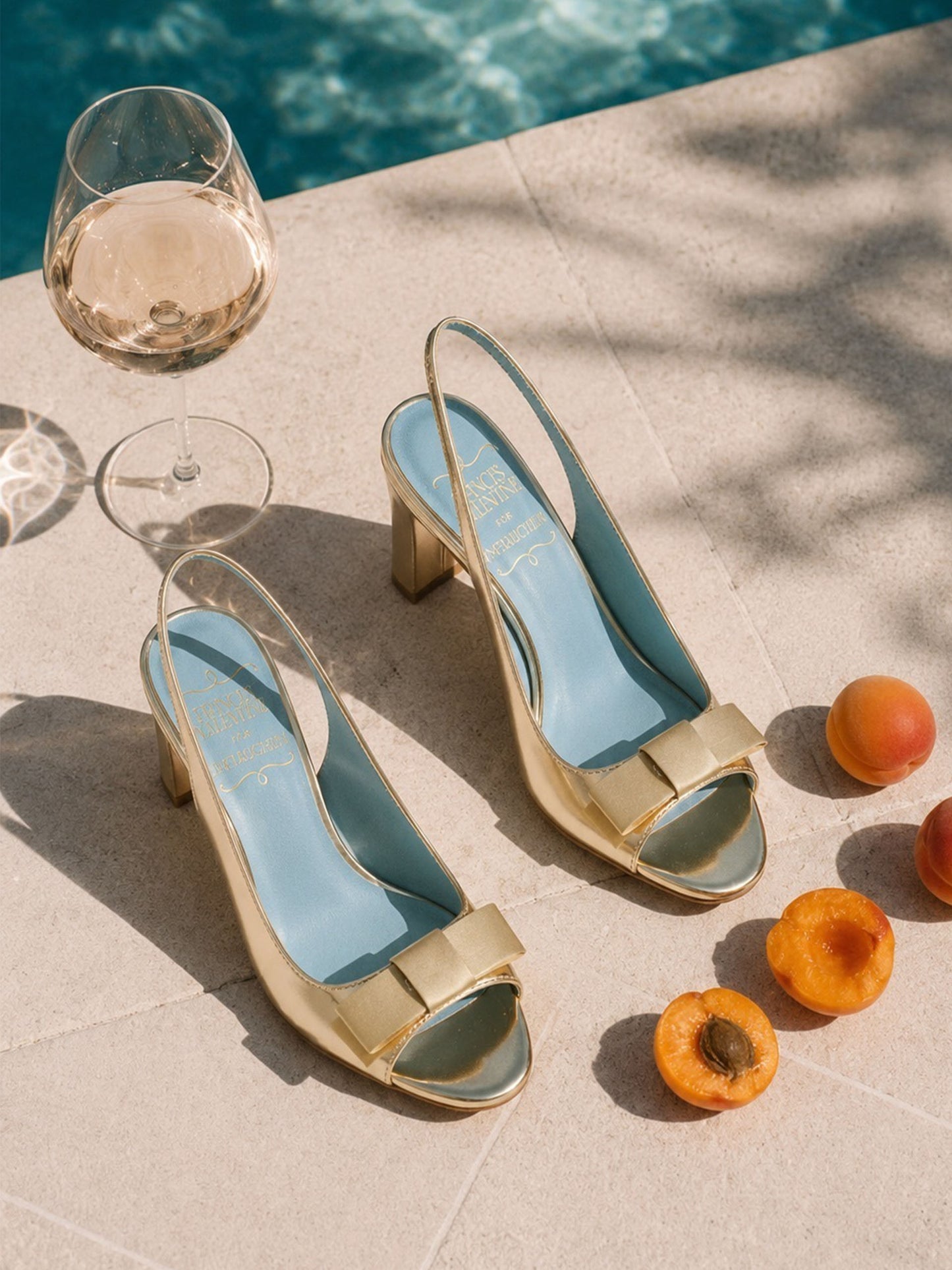 Reese Slingbacks by J.McLaughlin displayed elegantly beside fresh apricots and a glass of white wine, showcasing effortlessly stylish, enduring designs and luxurious craftsmanship.