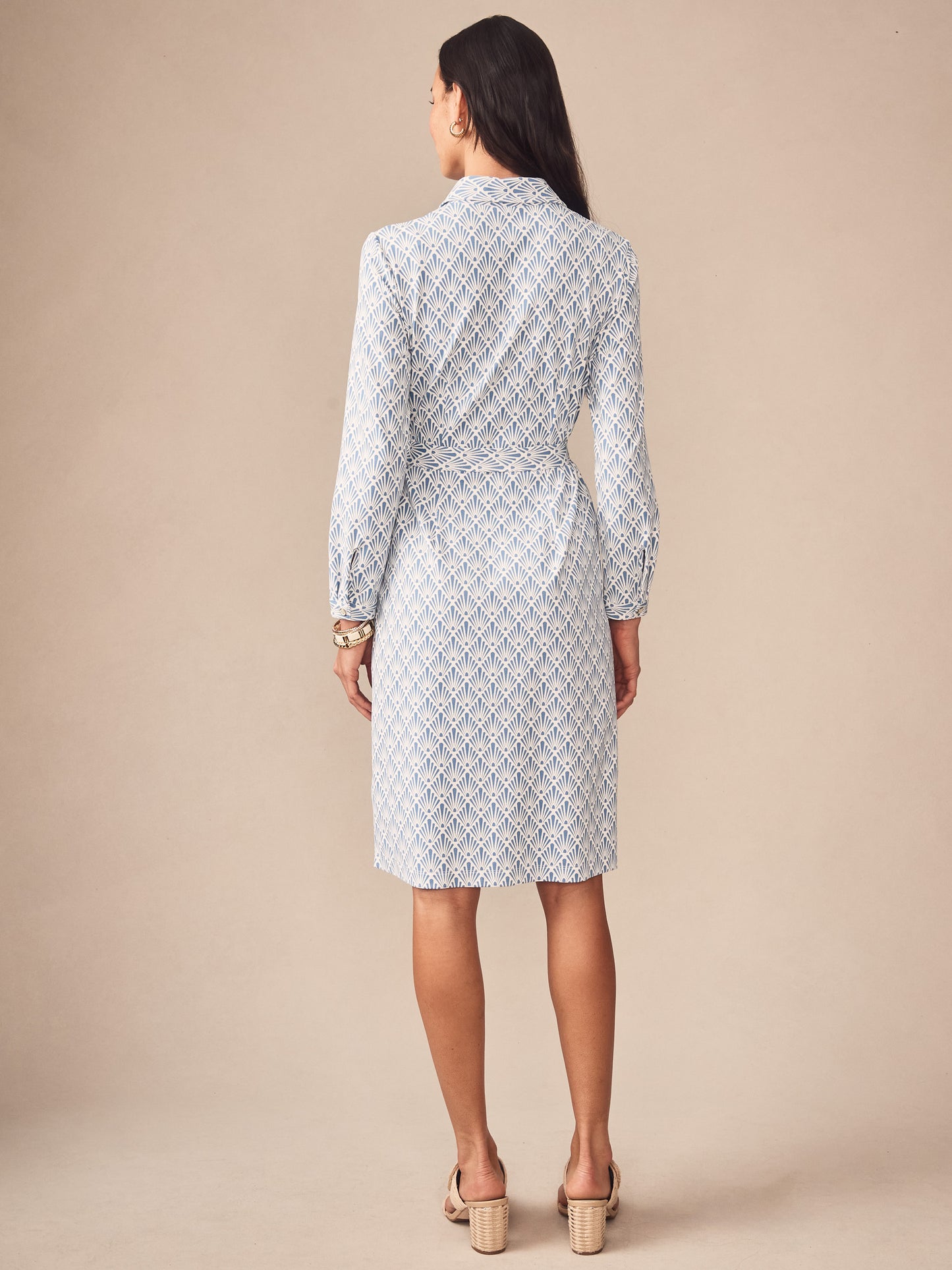 Woman wearing the Haarlem Dress in Sandshell by J.McLaughlin, featuring a classic patterned fabric and a tailored belt, embodying effortlessly stylish, enduring designs.