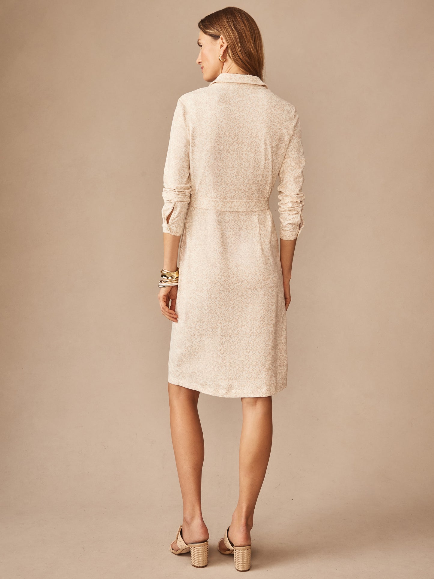 Woman modeling the Haarlem Dress in Mini Drawing Room by J.McLaughlin, featuring a soft off-white fabric with subtle tan details, showcasing effortlessly stylish, enduring designs in a classic silhouette. A destination for defining style. Life, Well-Lived.
