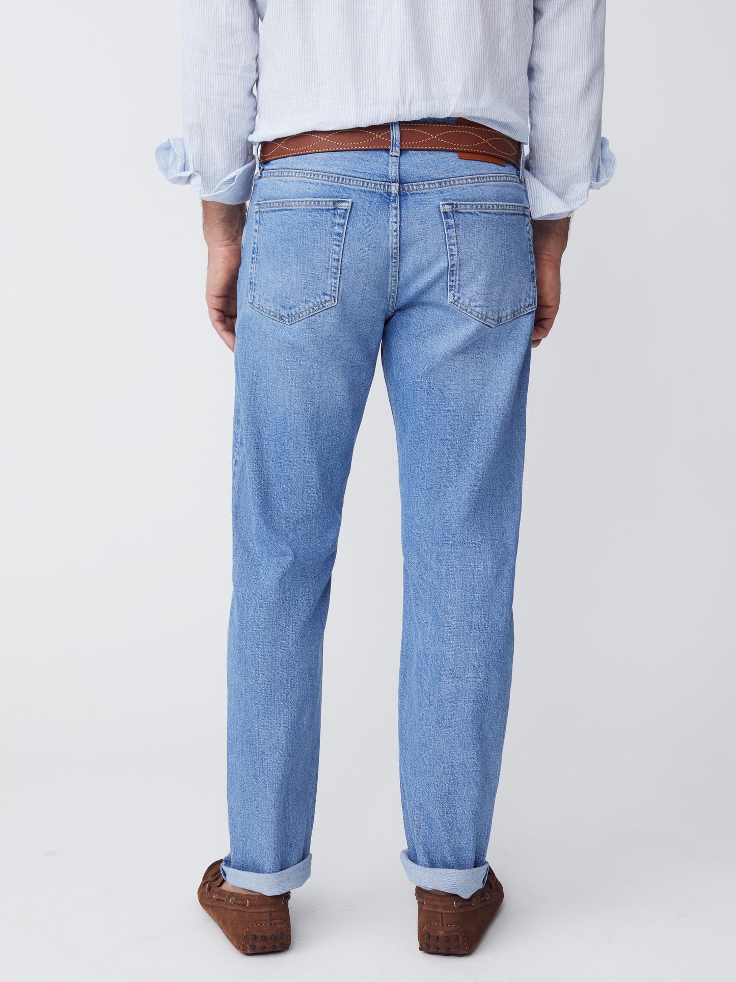 Model wearing J.McLaughlin Hyland jeans in sun faded denim made with cotton.
