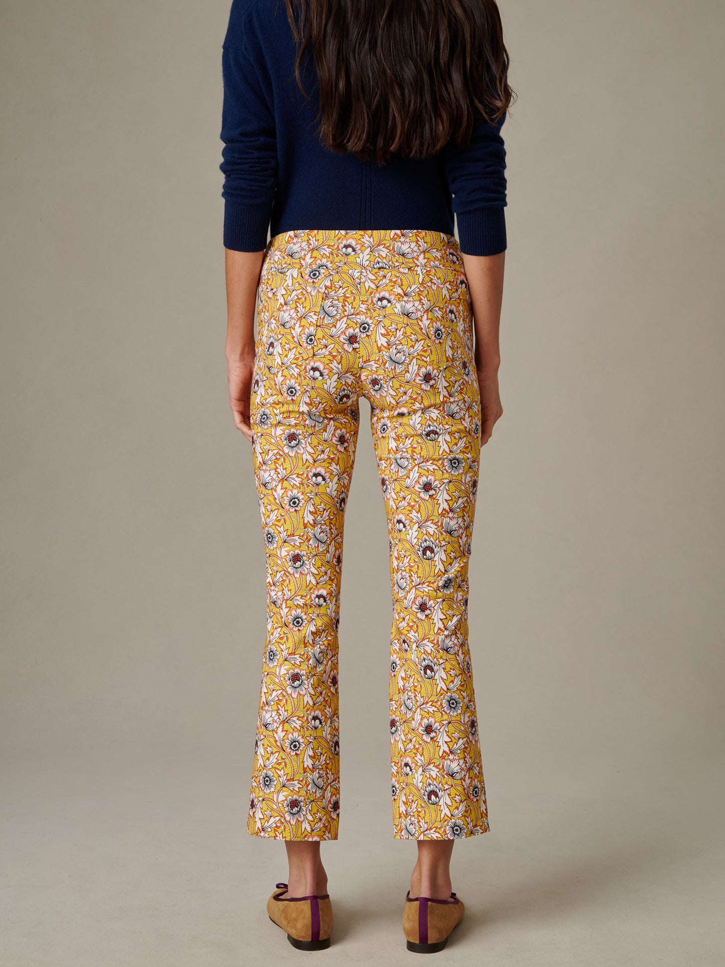 Woman wearing Ivy Pants in Belle Epoque Bloom with a floral print, paired with a navy sweater and brown flats, showcasing J.McLaughlin’s effortlessly stylish and enduring design.