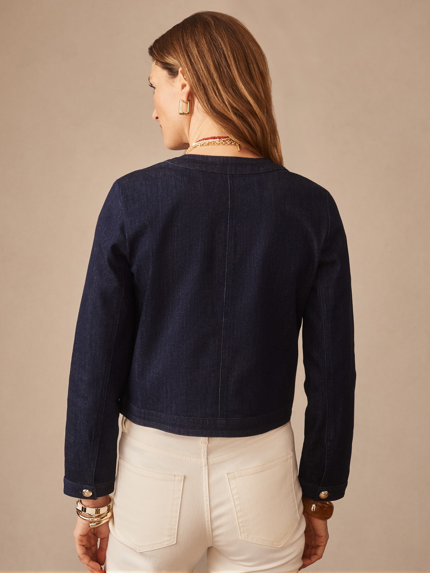 Woman wearing a Jackie Denim Jacket by J.McLaughlin in a classic indigo denim, paired with white pants, showcasing effortlessly stylish and enduring designs from a destination for defining style. Life, Well-Lived.