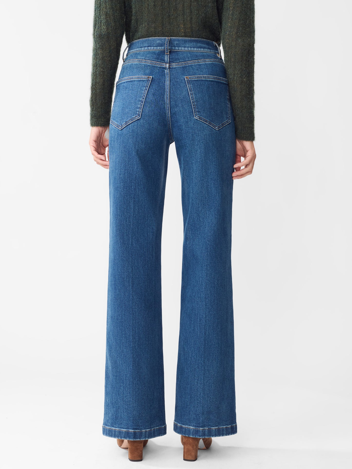 Model wearing J.McLaughlin Lowden jeans in dark indigo made with cotton.