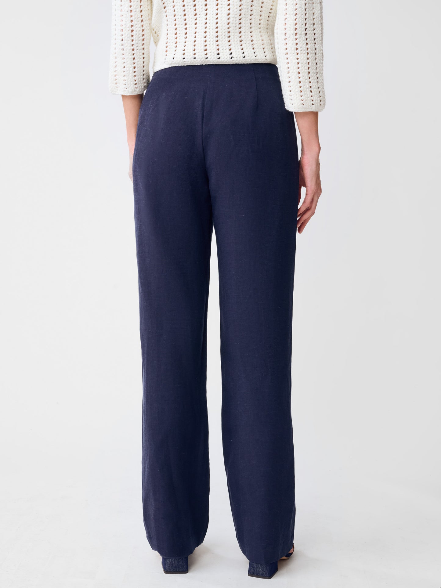 Back view of a person wearing navy Kilian Linen Blend Pants by J.McLaughlin paired with a white textured sweater, showcasing effortlessly stylish and enduring designs for a legacy of timeless fashion.