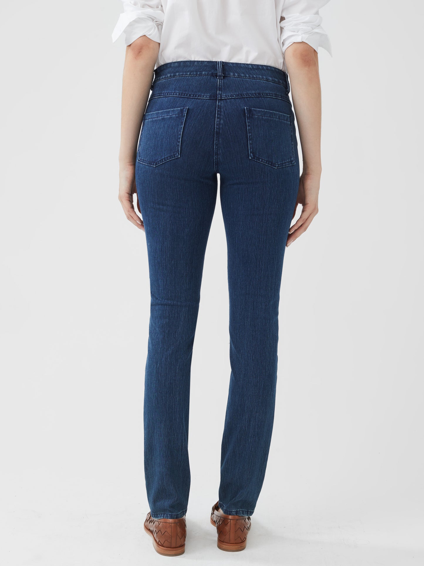 Model wearing J.McLaughlin Lexi jeans in dark denim made with woven denim (cotton).