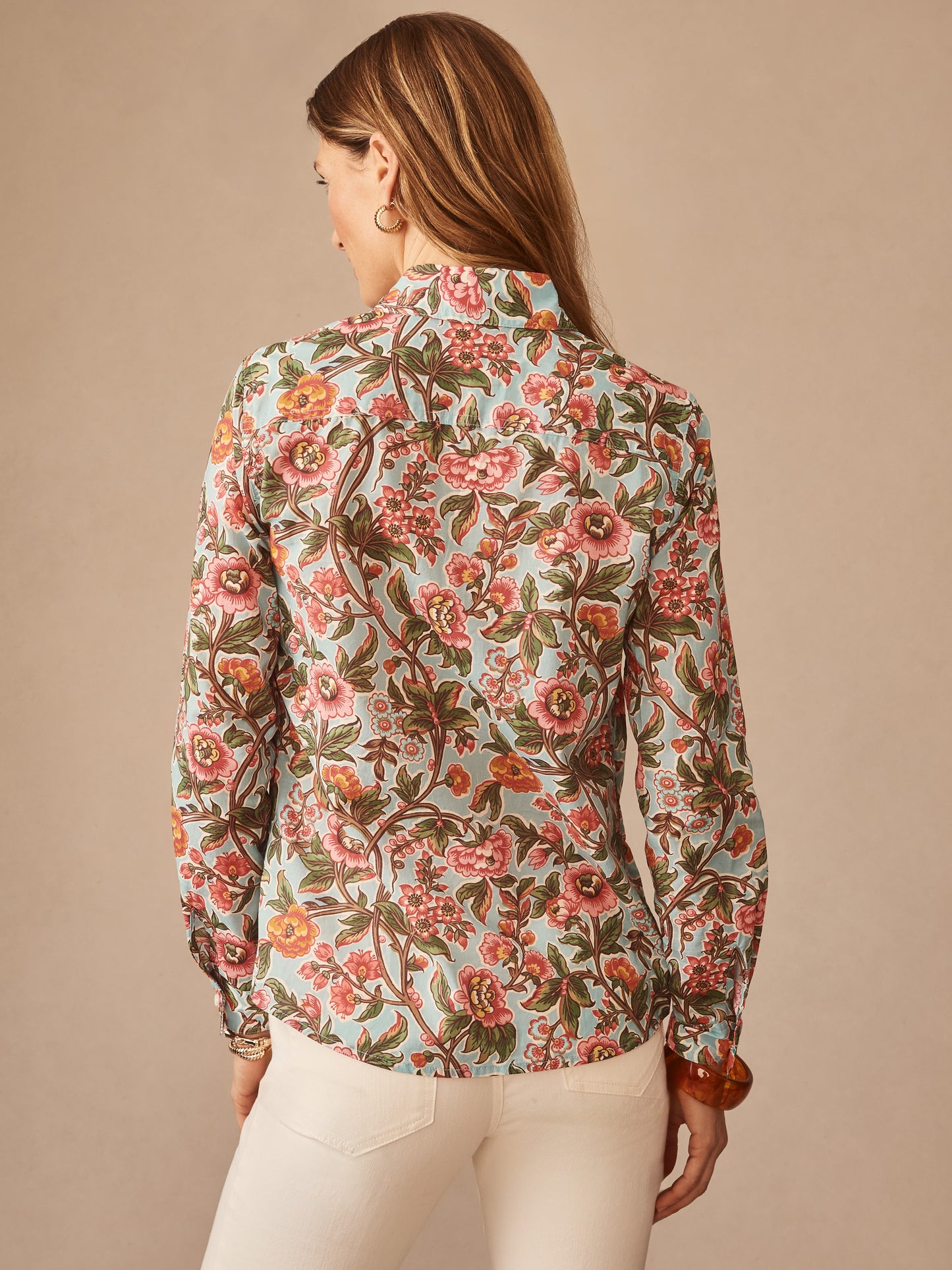 Woman wearing the Lois Shirt in Bucolic Beekeeper by J.McLaughlin, featuring a floral pattern in soft blue, coral, and earthy tones, showcasing effortlessly stylish and enduring designs.