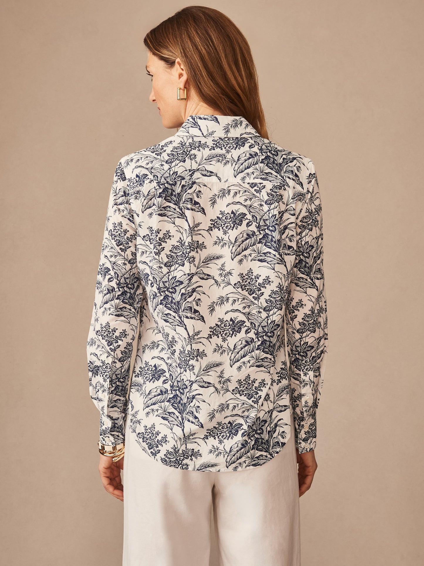Woman wearing a J. McLaughlin Lois Shirt in Giardino Toile Stripe with an elegant navy floral pattern on white, showcasing effortlessly stylish, enduring designs and innovative fabrics.