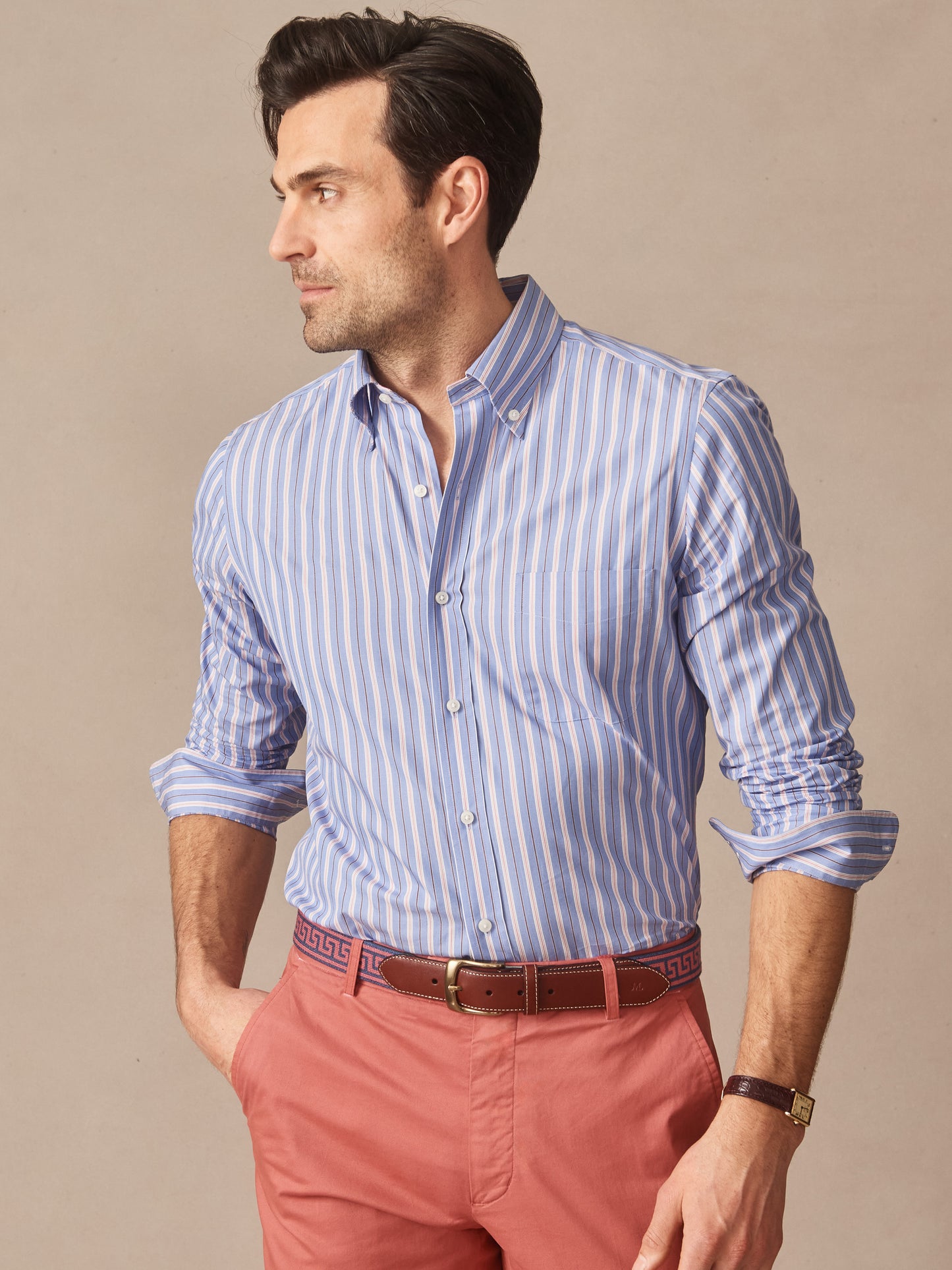 Man wearing a Belvedere Cotton Shirt in Multi Stripe with blue and white vertical stripes paired with red pants and a brown belt, showcasing J.McLaughlin’s effortlessly stylish, enduring designs and innovative fabrics. A destination for defining style. Life, Well-Lived.