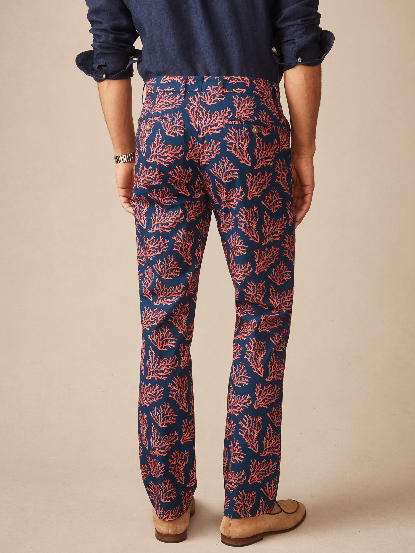 Man wearing Madison Fancy Pants in Midi Coral Cay Texture by J.McLaughlin, featuring effortlessly stylish coral pattern on navy pants, showcasing enduring designs and innovative fabrics.