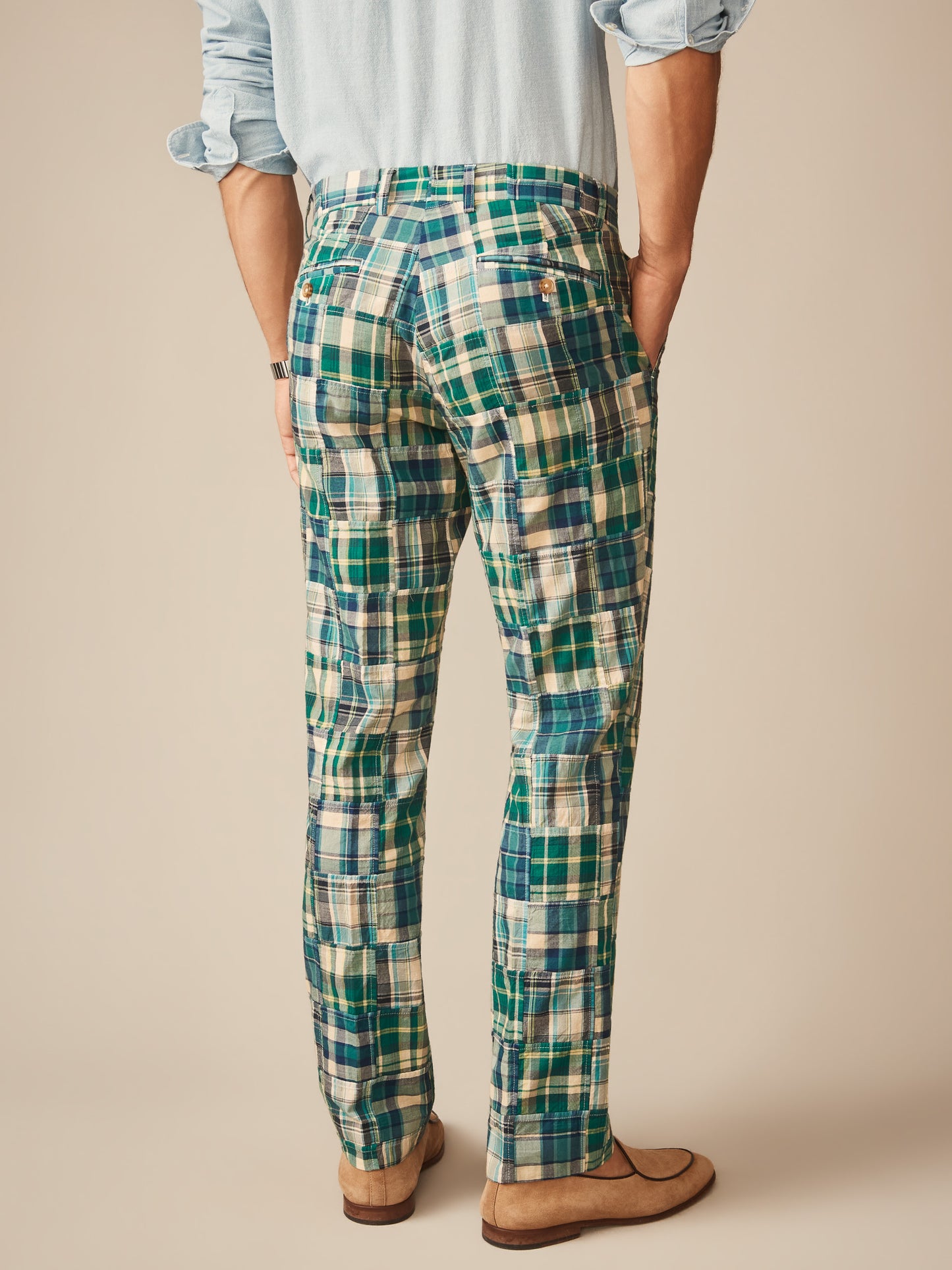 Back view of a man wearing Madison Fancy Pants in Patchwork by J.McLaughlin, featuring green and blue plaid pants paired with a light blue shirt and tan shoes, showcasing effortlessly stylish, enduring designs made with innovative fabrics for a legacy of timeless fashion. A destination for defining style. Life, Well-Lived.