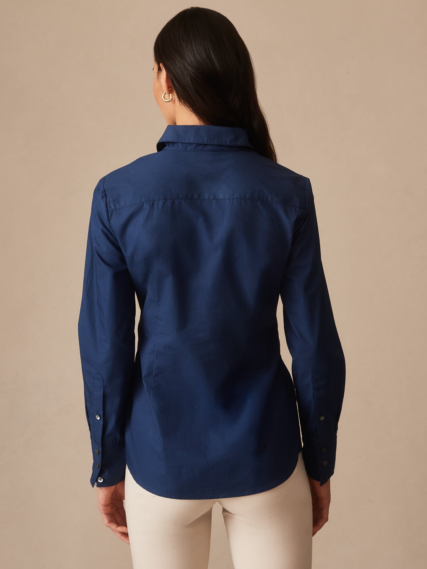 Woman wearing a navy blue Margaux Shirt by J.McLaughlin, showcasing an effortlessly stylish design with innovative fabrics and impeccable craftsmanship, a destination for defining style. Life, Well-Lived.