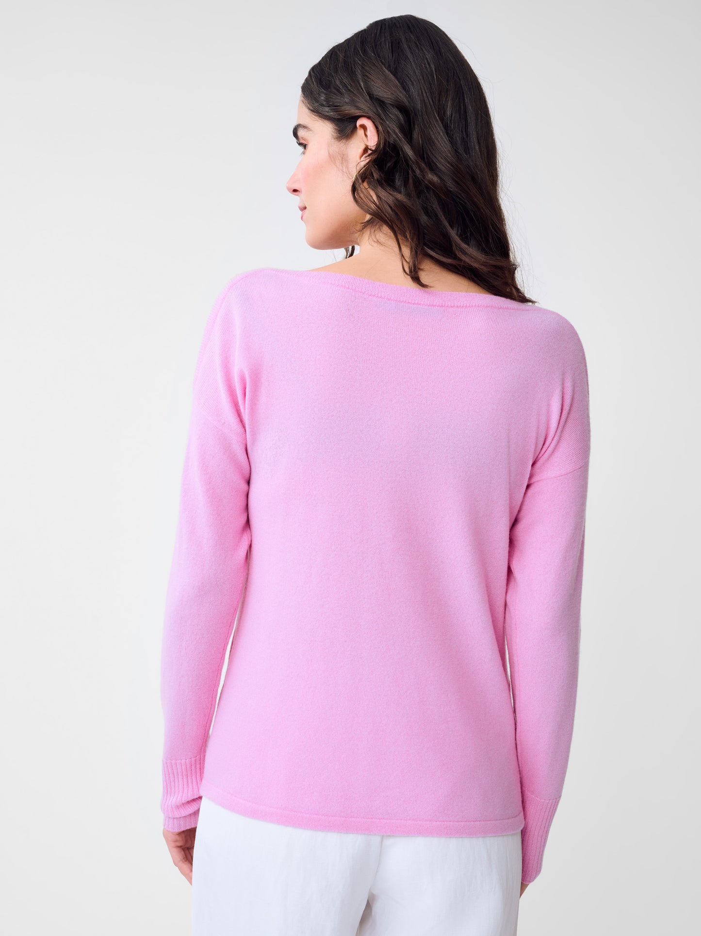 Woman seen from behind wearing a pink Marin Cashmere Sweater by J.McLaughlin, showcasing impeccable craftsmanship and effortlessly stylish, enduring designs for a life well-lived.