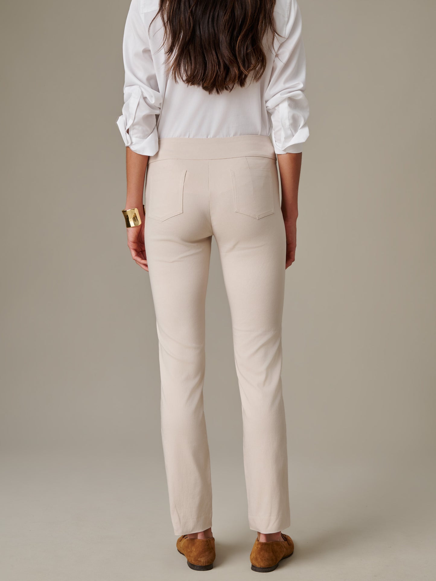 Woman wearing cream-colored Masie Pants by J.McLaughlin paired with a white blouse, showcasing effortlessly stylish and enduring design for timeless fashion.