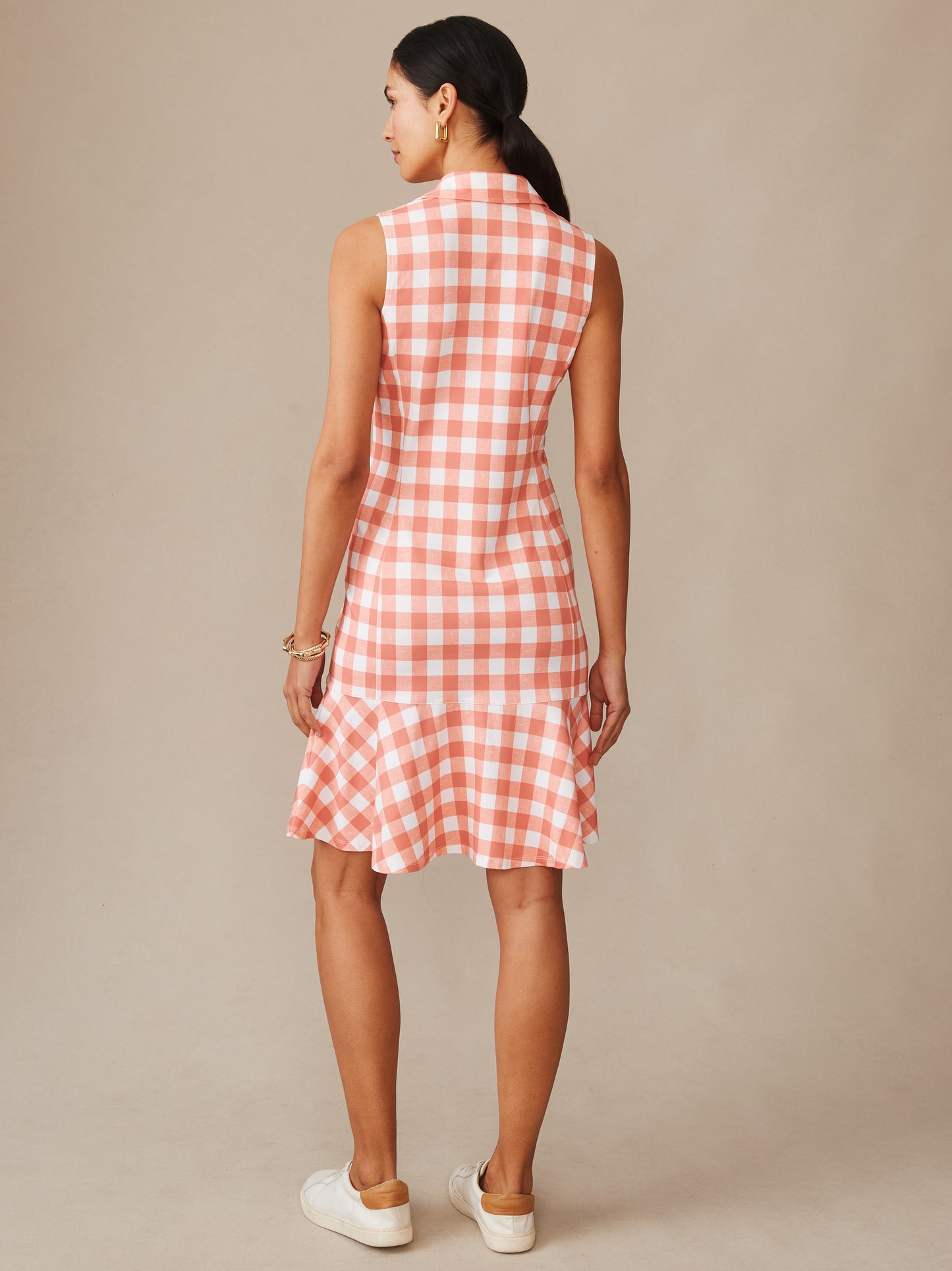 Woman wearing a sleeveless Merlin Dress in Textured Gingham by J.McLaughlin in soft coral and white, showcasing an effortlessly stylish, enduring design in innovative fabric for a legacy of timeless fashion. A destination for defining style. Life, Well-Lived.