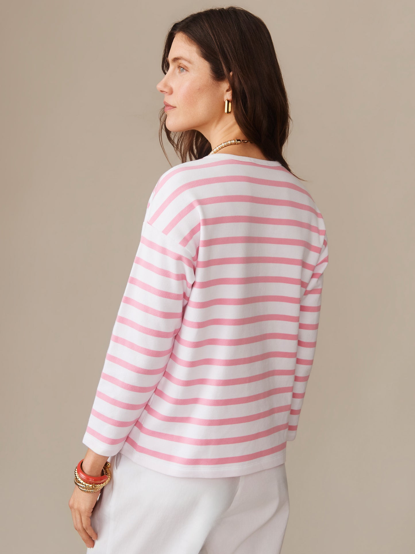 Woman wearing a pink and white striped Nico Tee in Stripe by J.McLaughlin, showcasing effortlessly stylish, enduring designs and innovative fabrics for a legacy of timeless fashion. A destination for defining style. Life, Well-Lived.