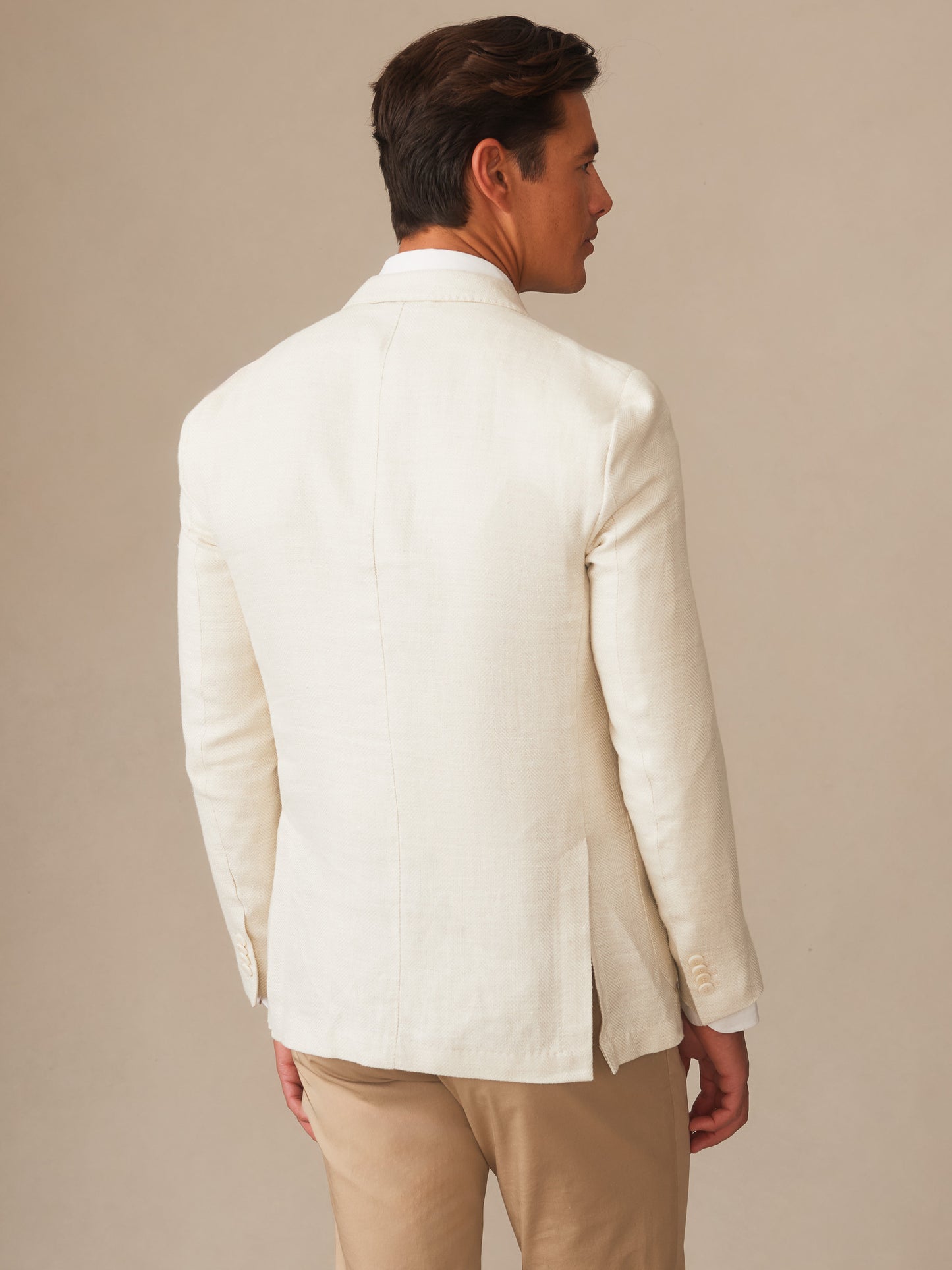 Man wearing a stone-colored Notting Blazer by J.McLaughlin, showcasing effortlessly stylish, enduring designs with innovative fabrics for a legacy of timeless fashion.