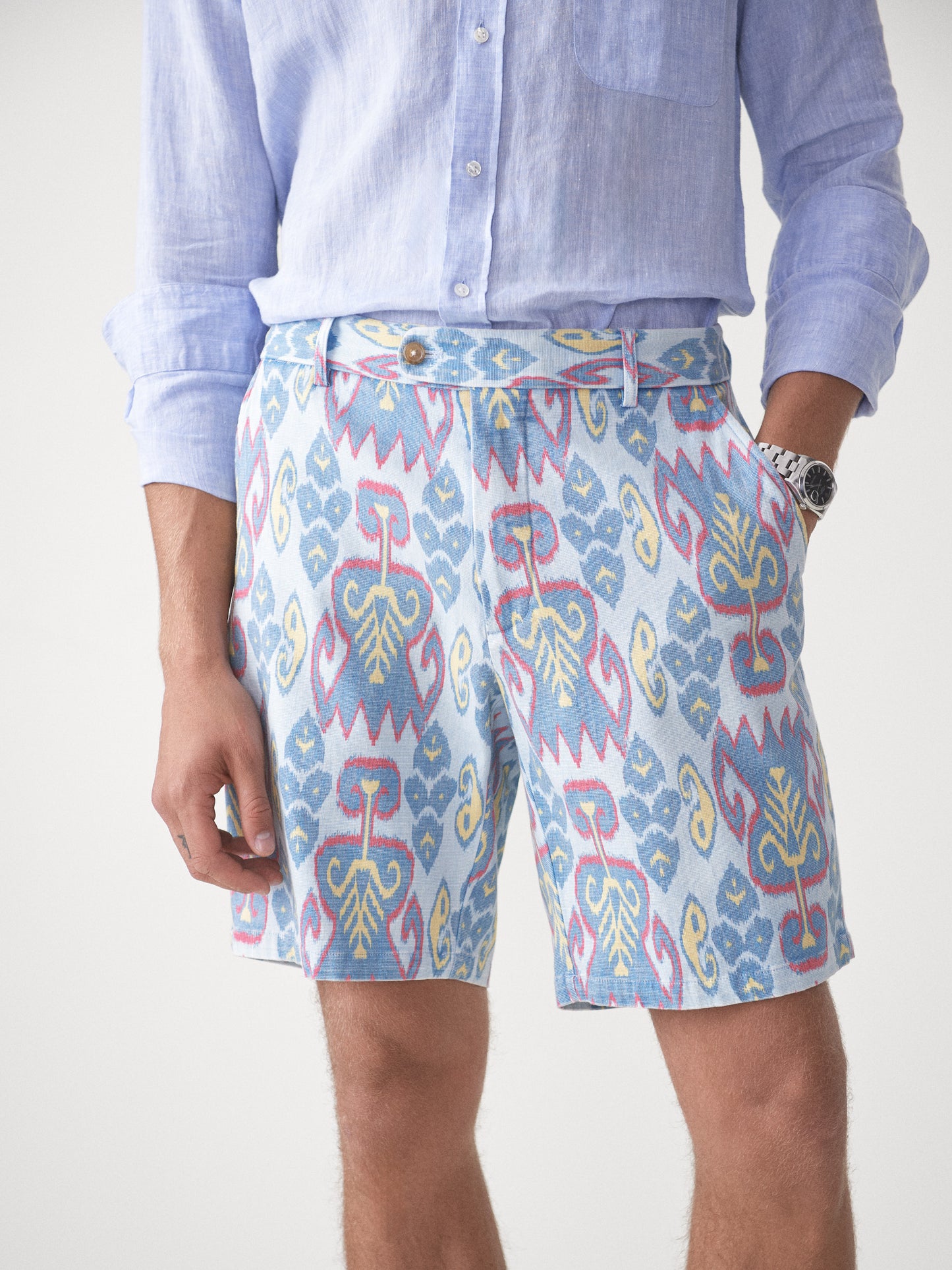 Model wearing J.McLaughlin Oliver shorts in aqua/blue/gold made with cotton.